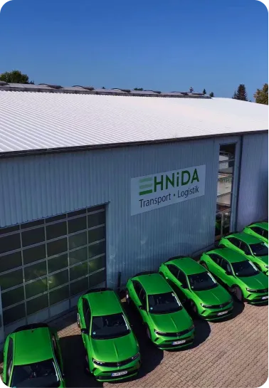 HNiDA-Firmenhalle mit dem Fuhrpark aus grünen Fahrzeugen