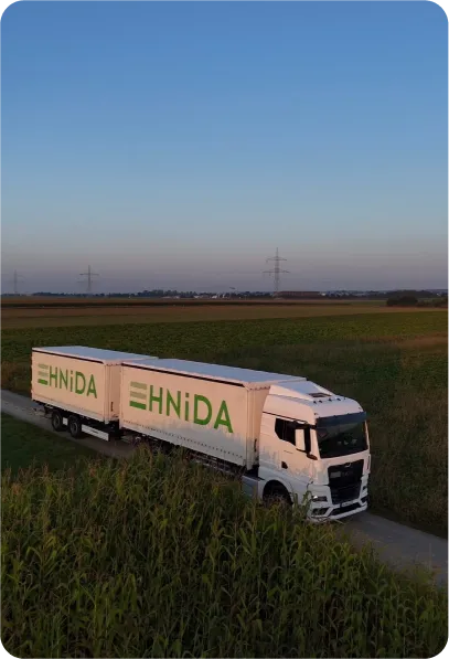HNiDA-Lastzug auf einer Straße zwischen Feldern in der Abenddämmerung