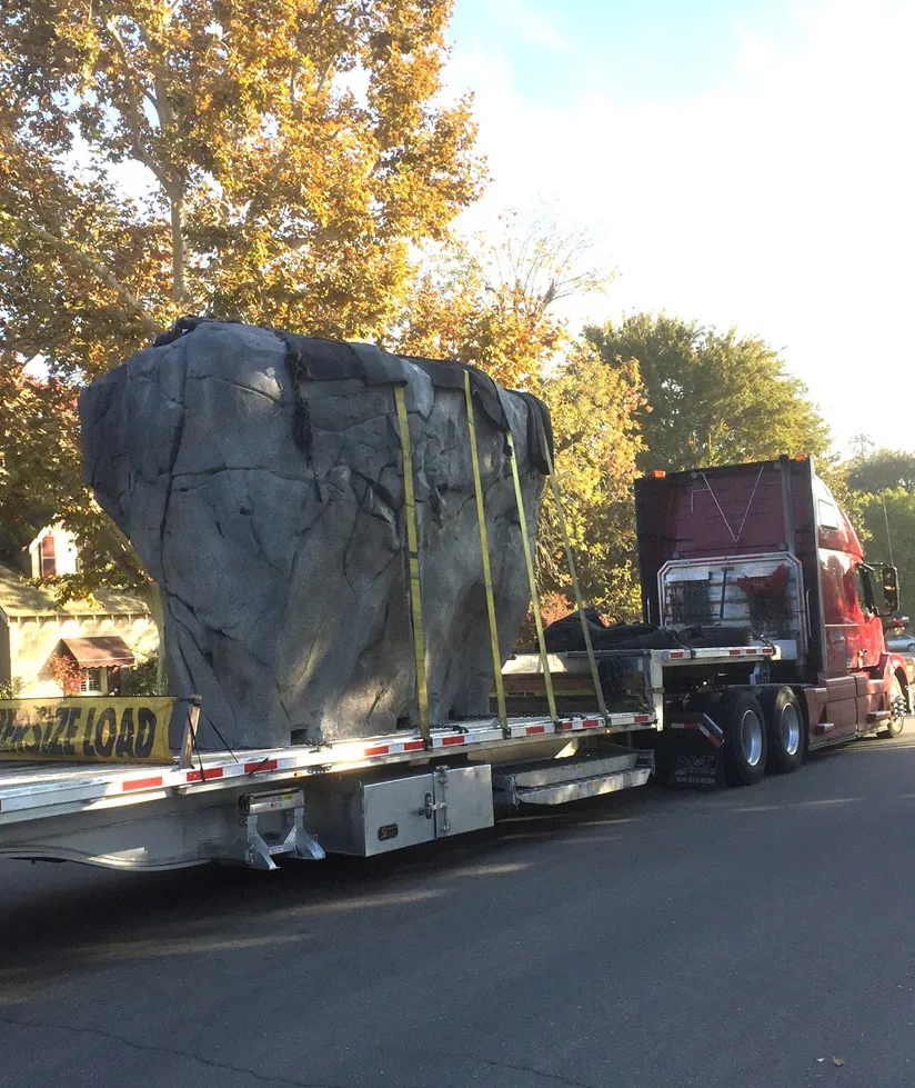 Various white and black climbing holds arranged on a wooden gym floor.