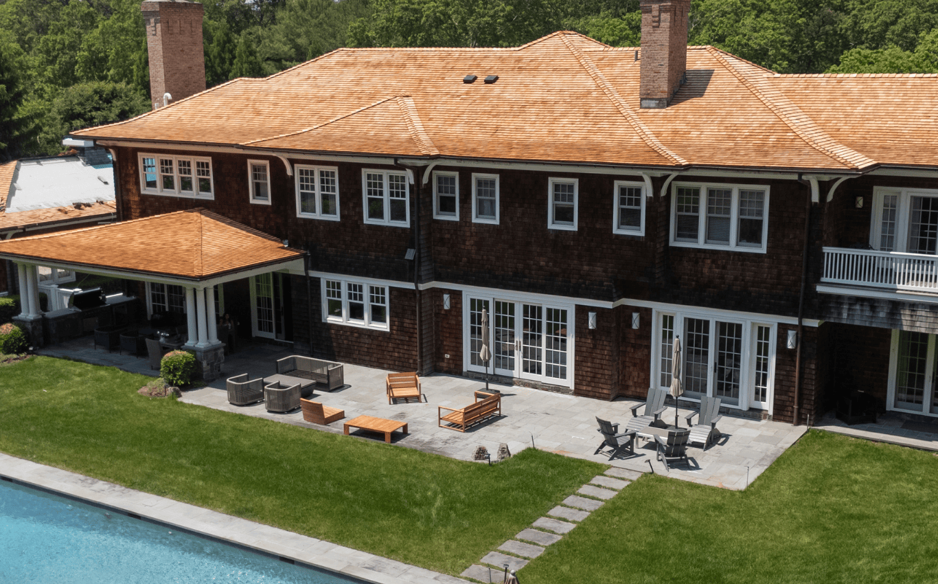 Luxury cedar roof paired with rich wood siding on a Hamptons-style home, showcasing Cedar Solutions Roofing’s craftsmanship and timeless coastal design.