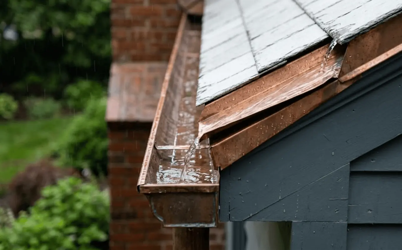 Close-up of roof edge with custom metal flashing and gutter guiding rainwater for proper drainage.