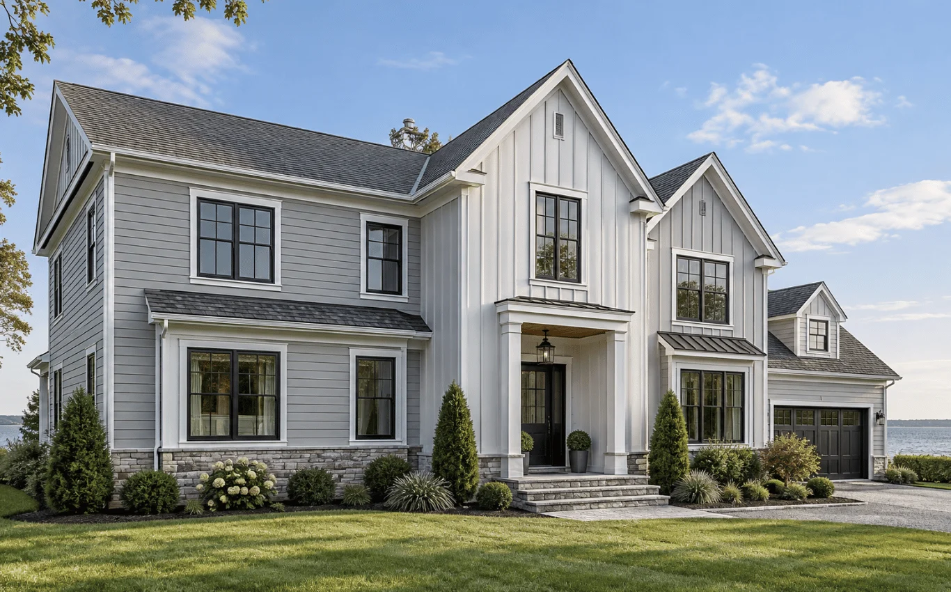 Modern Long Island home with gray horizontal siding, white vertical board-and-batten siding, black-framed windows, and stone accents.