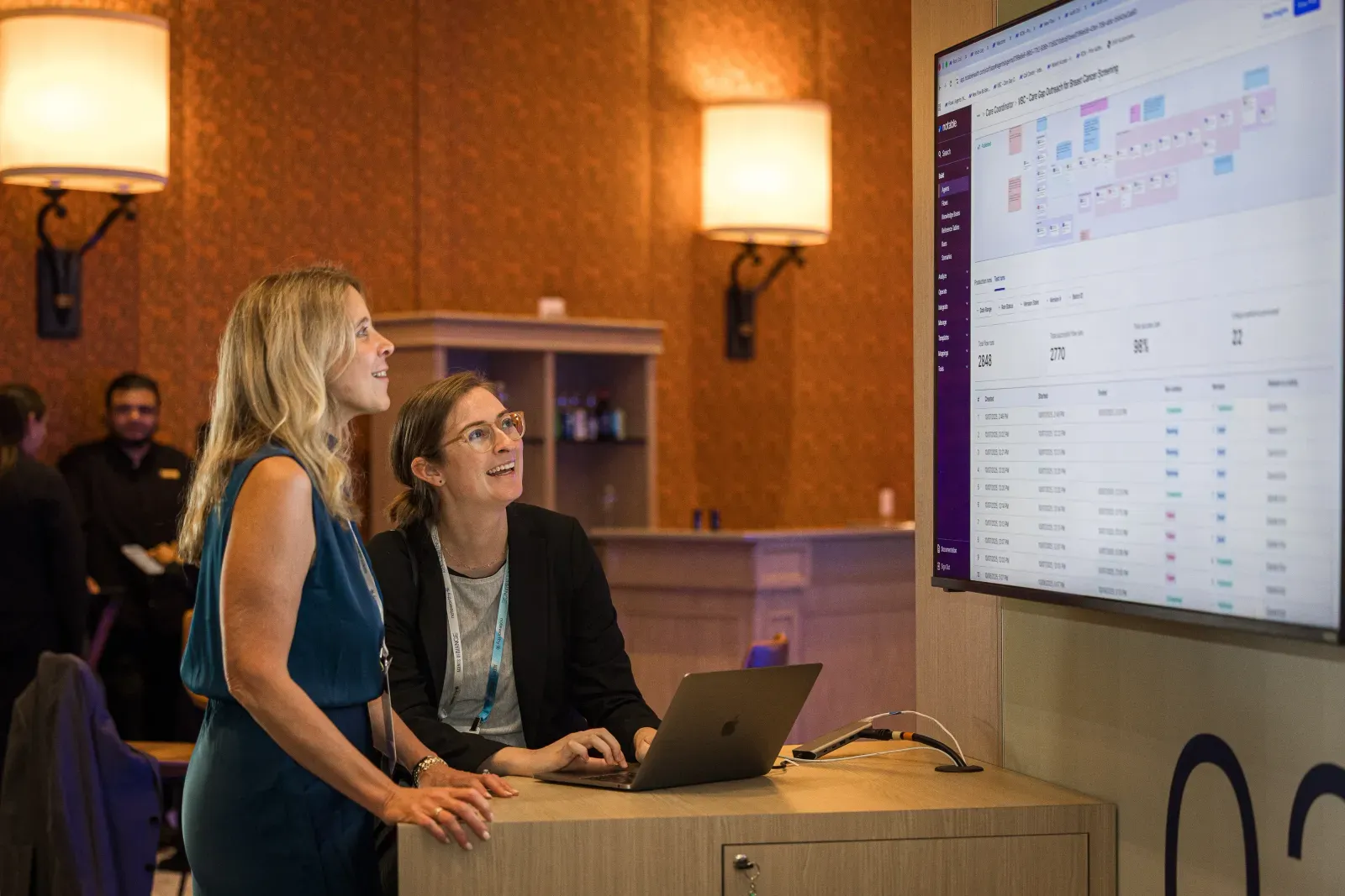Two team members reviewing event data on a wall display