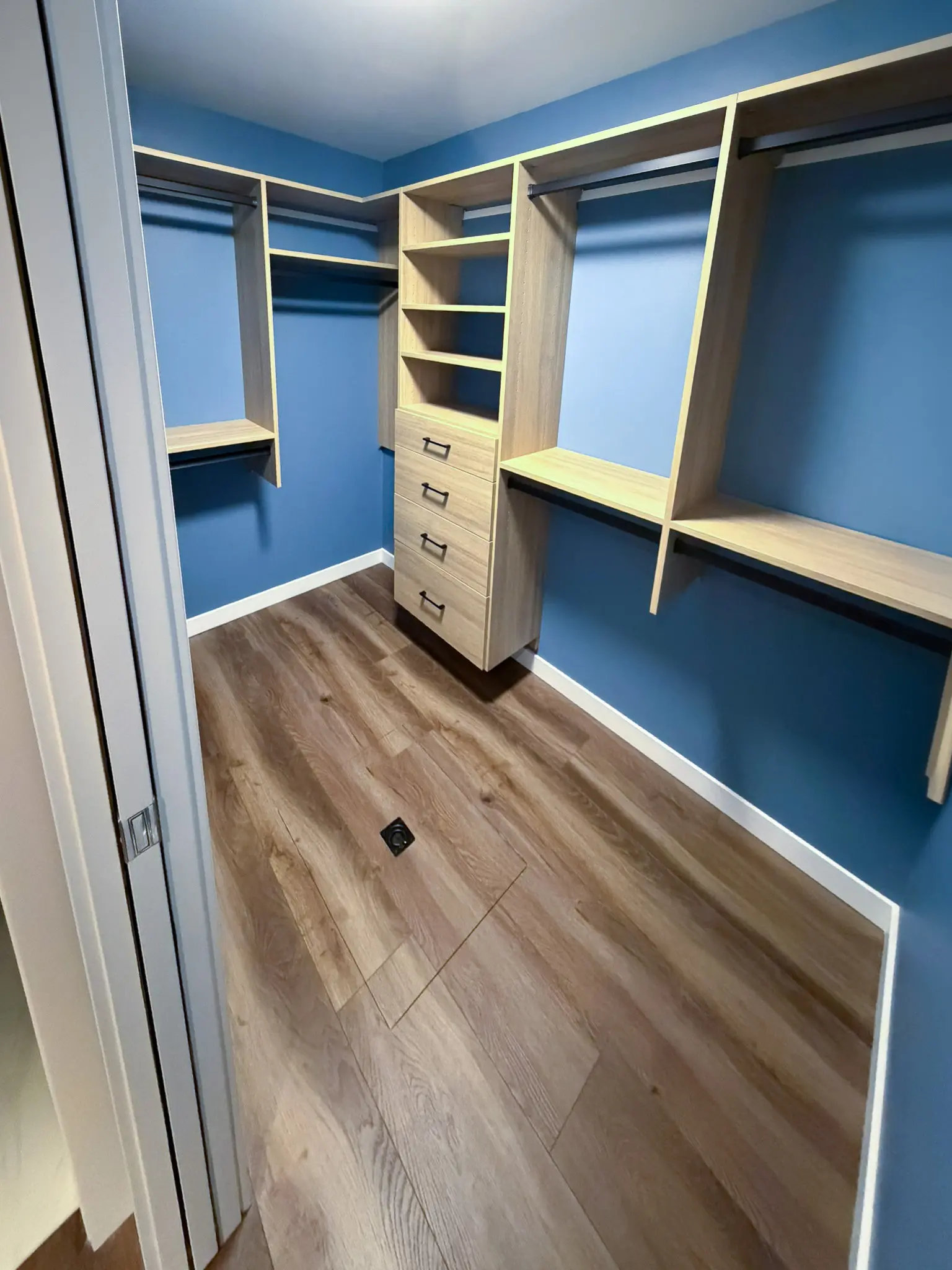 Closet with built-in wood-tone shelving, hanging rods, and drawers in the completed Kirkland, WA mother-in-law apartment addition.
