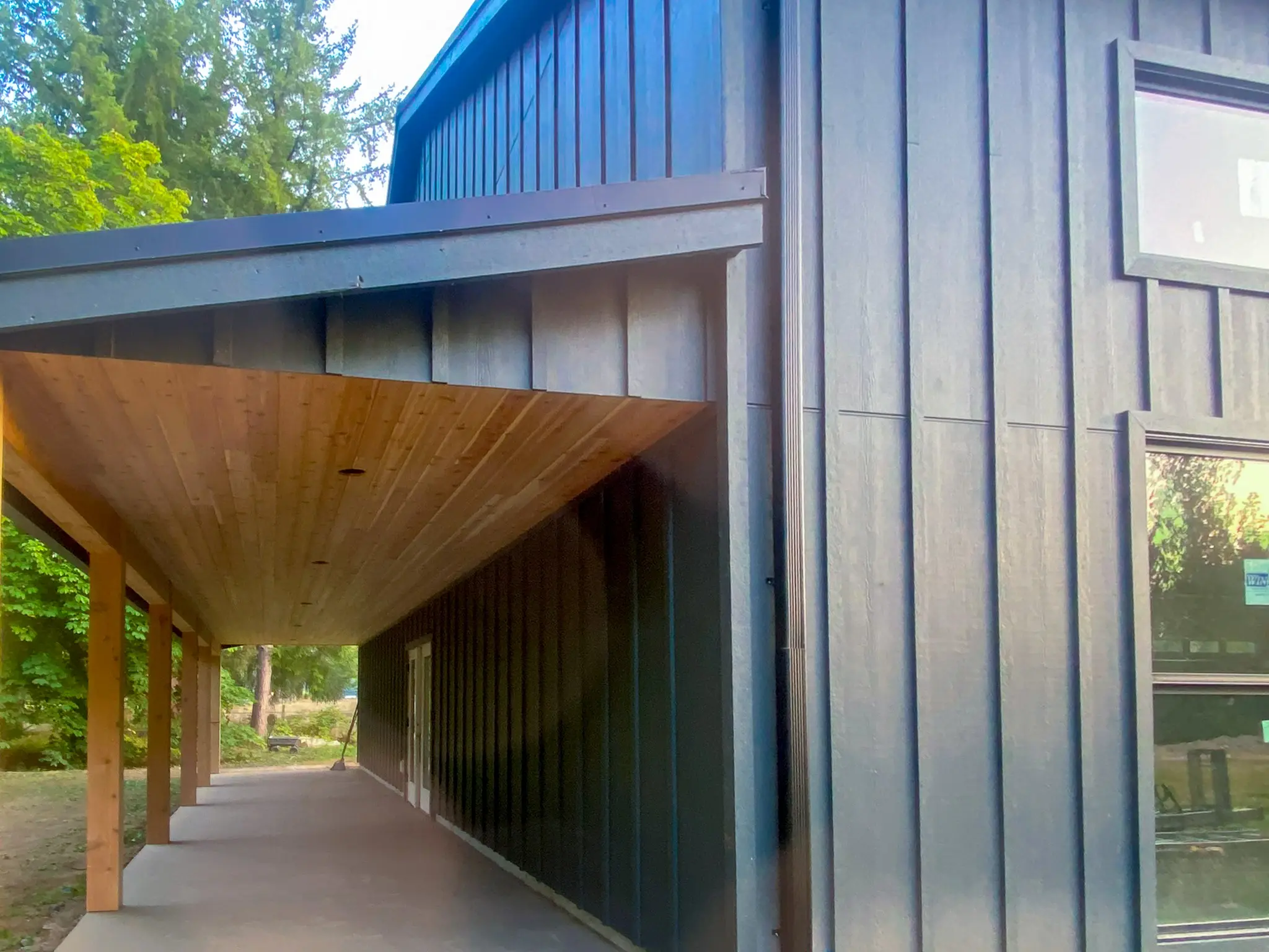 Covered walkway along the completed detached shop in Fall City, WA, with a wood-plank ceiling and timber posts.