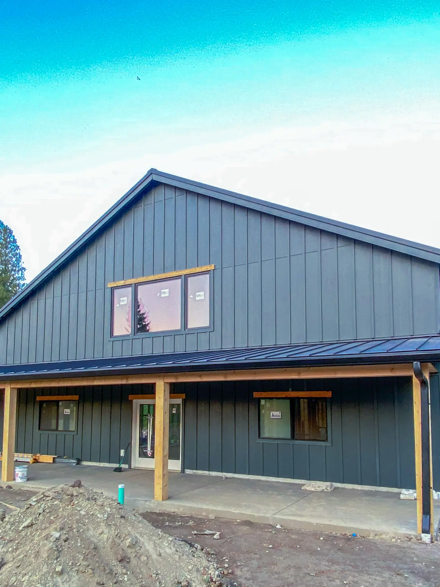 Gable end of the completed detached shop in Fall City, WA, with a covered porch and single entry door.