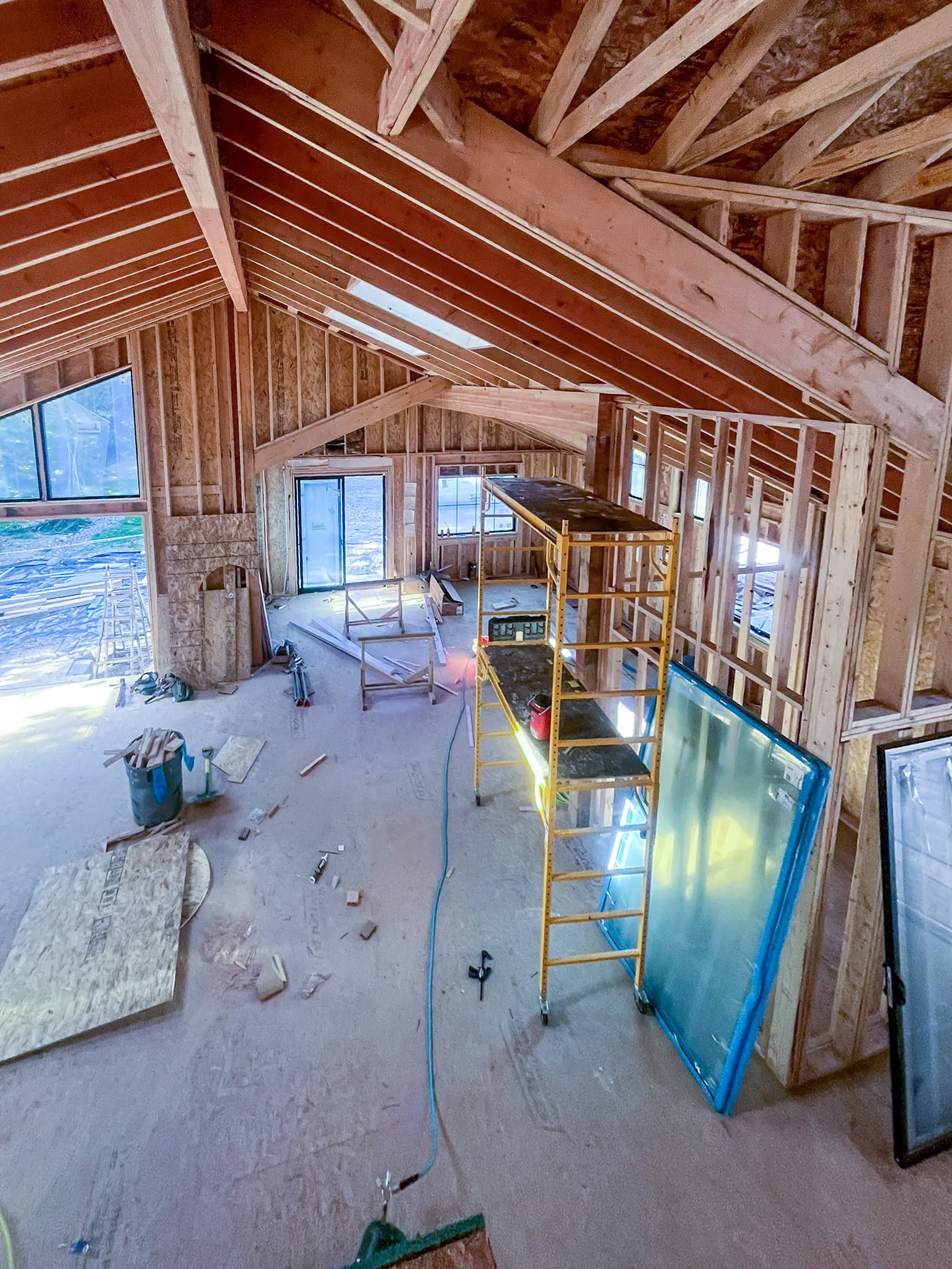 Vaulted ceiling framing and scaffolding in an open room under construction for a new custom home in Redmond, WA.