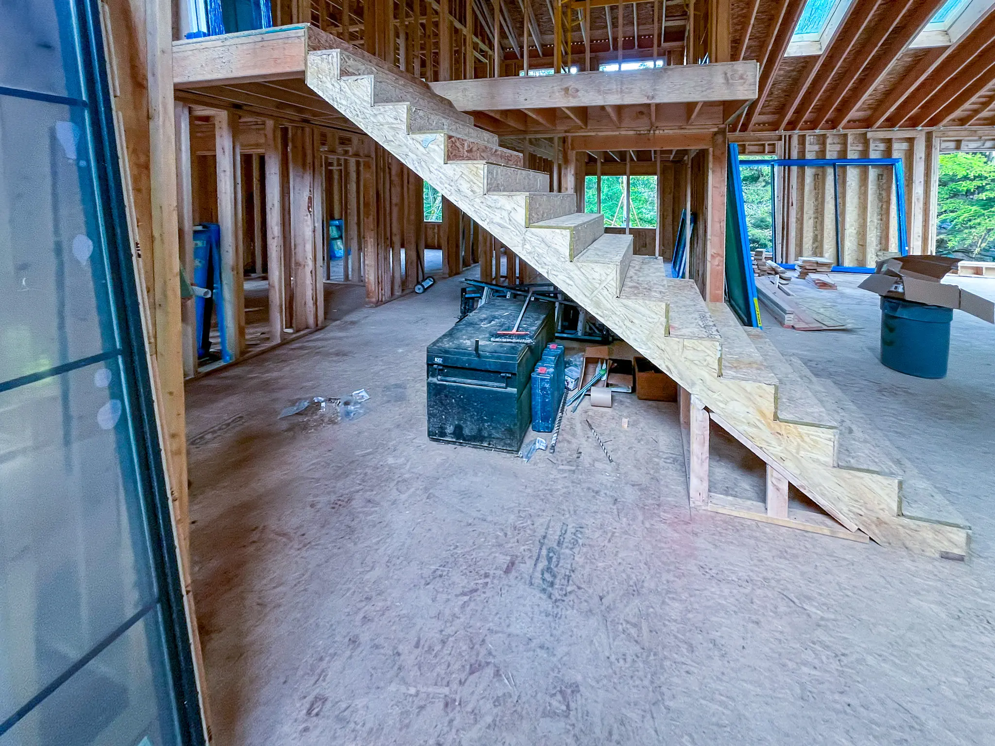 Interior wood framing with an open staircase under construction for a new custom home in Redmond, WA.