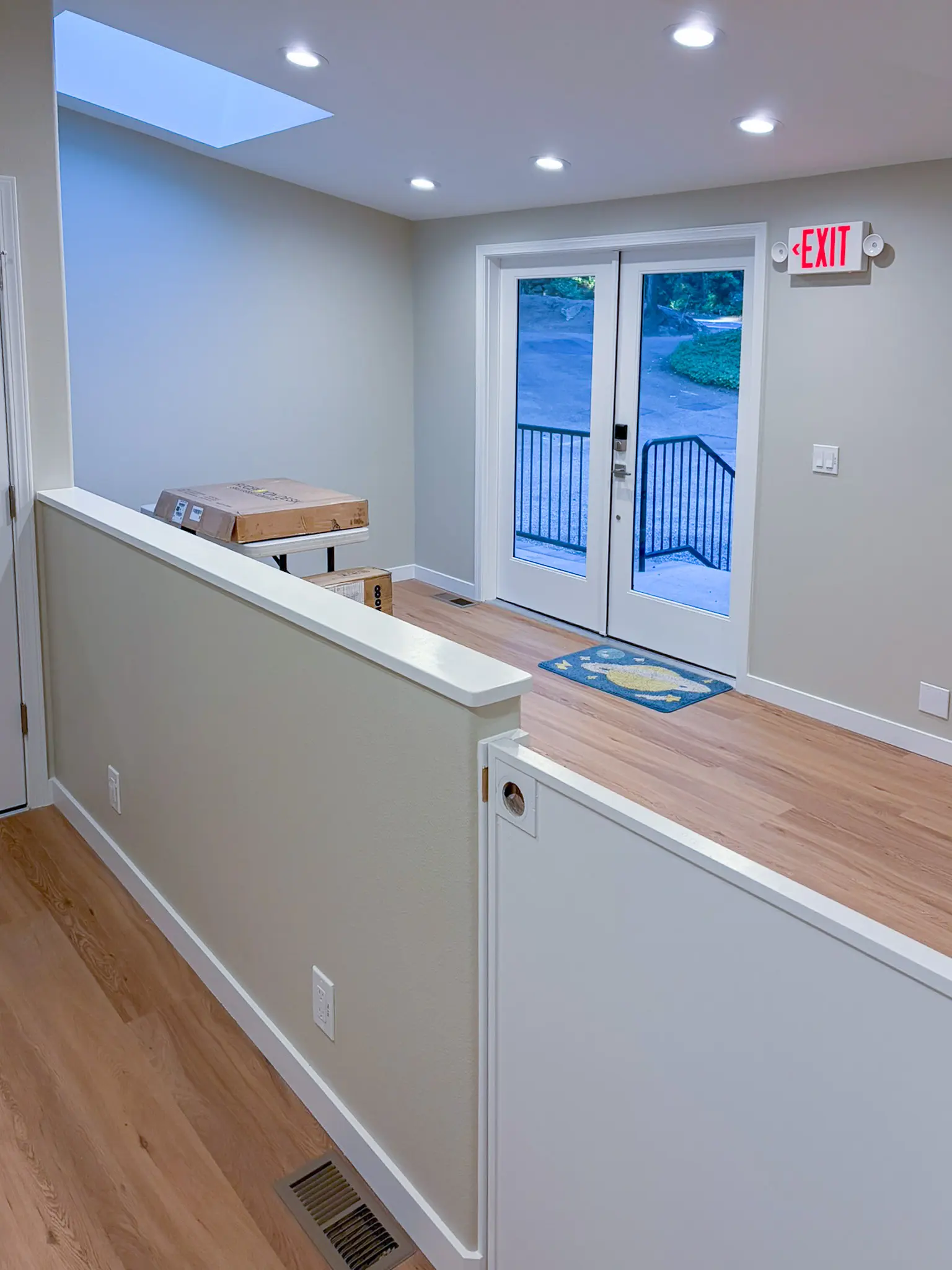 Entry area with a half-wall divider and glass exit doors in the remodeled Redmond, WA daycare.