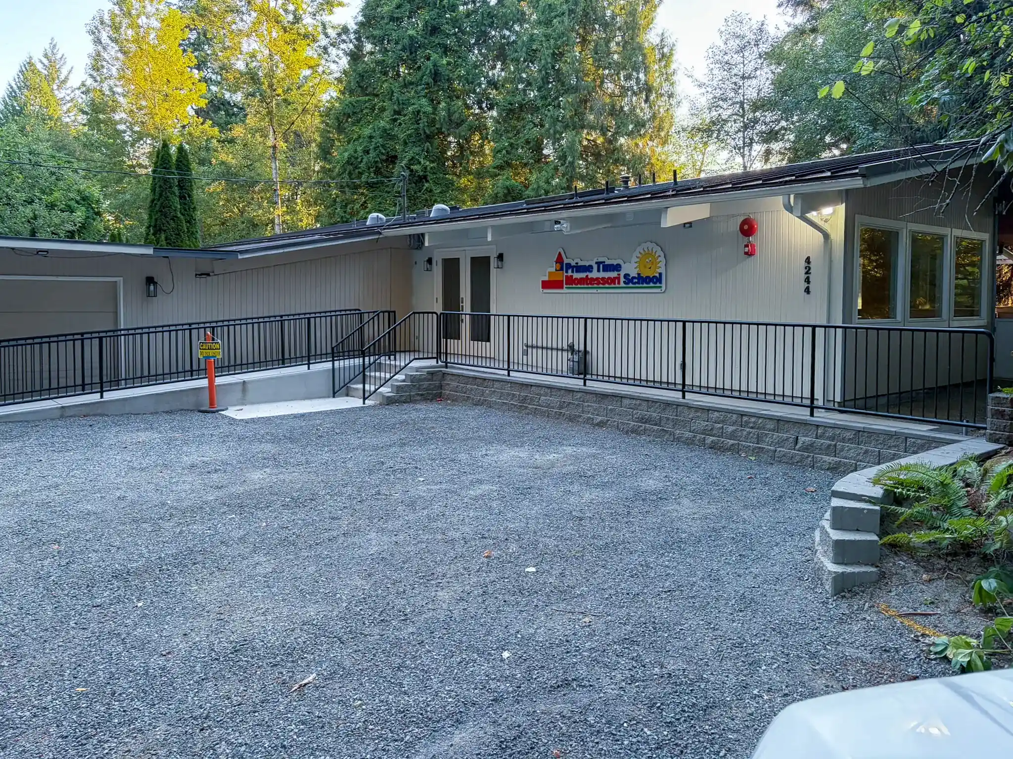 Exterior of the remodeled Redmond, WA daycare building with a new accessible entry ramp, metal railing, and covered entrance.