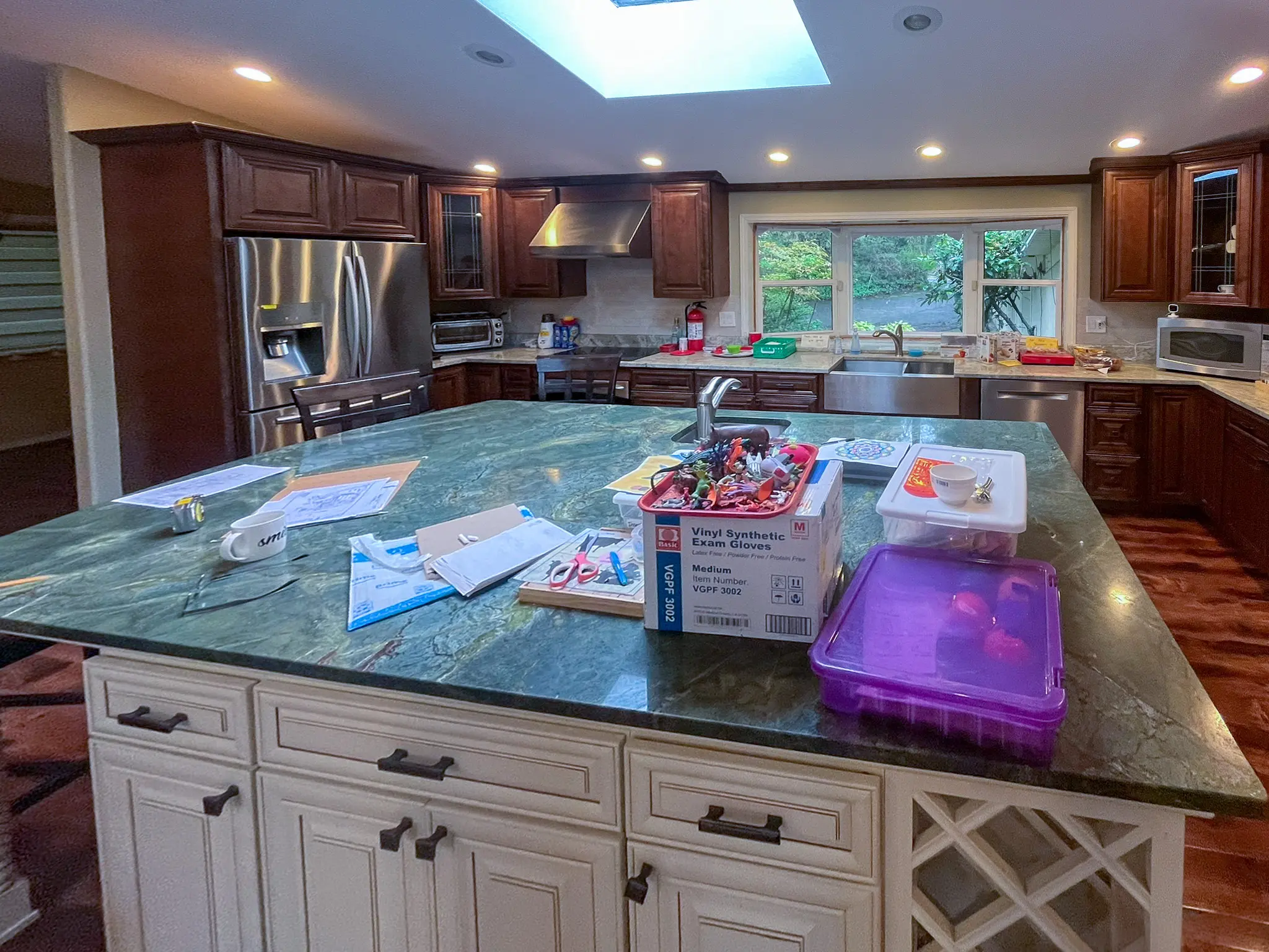 Kitchen with a large island and dark wood cabinets in a Redmond, WA commercial building before a daycare remodel.