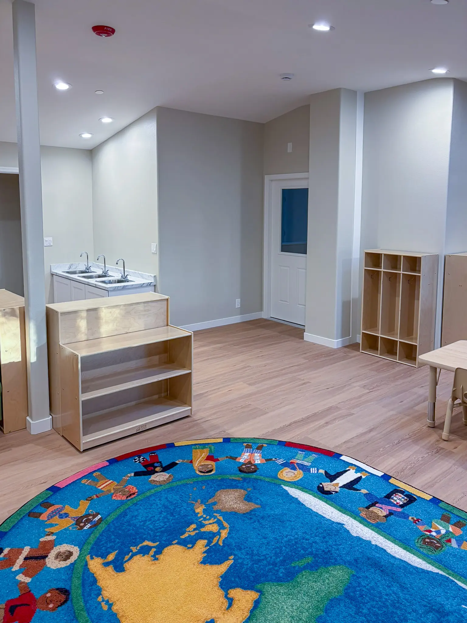 Classroom area with a triple-basin sink counter and storage cubbies in the remodeled Redmond, WA daycare.