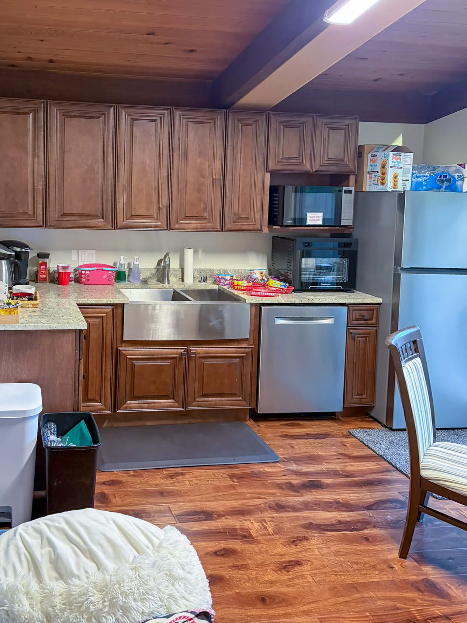 Existing kitchen with wood cabinets and a farmhouse sink in a Redmond, WA commercial building before a daycare remodel.