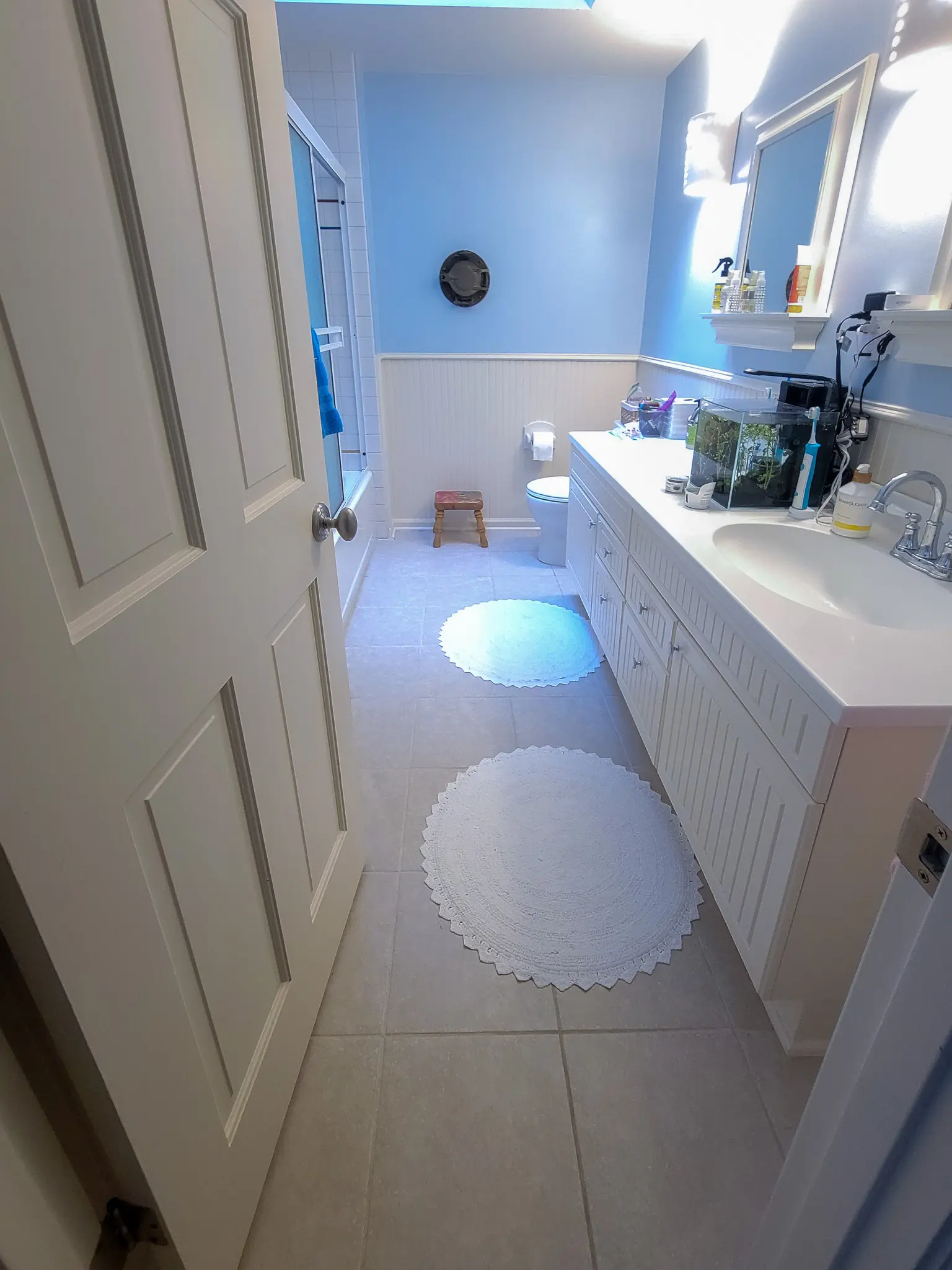 Existing bathroom with blue walls, a tub-shower combo, and a vanity in a Bellevue, WA home before a bathroom remodel.