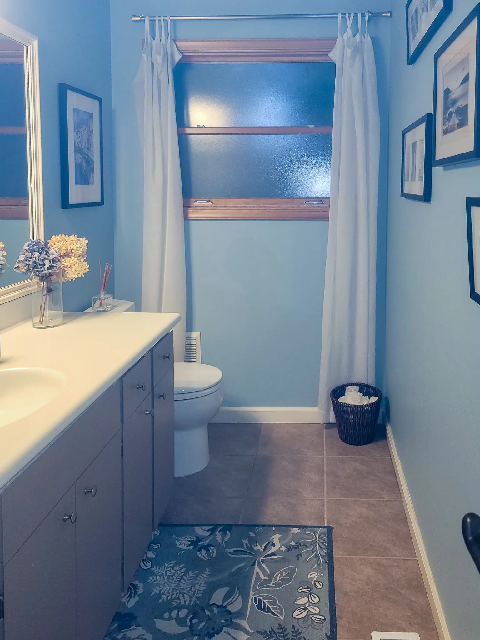 Existing small bathroom with blue walls and a single vanity in a Bellevue, WA home before a bathroom remodel.