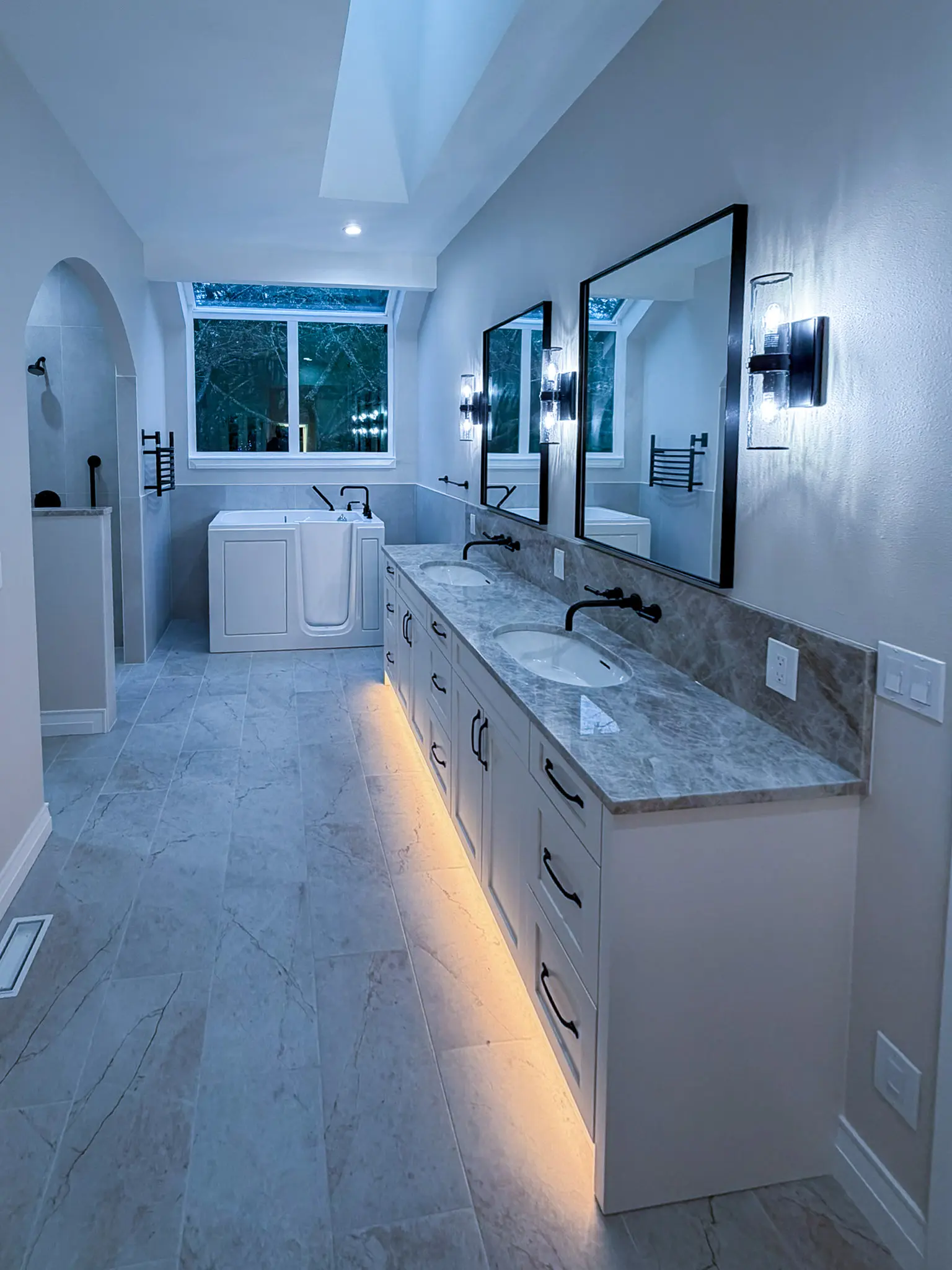 Primary bathroom with a walk-in soaking tub with a low-entry door, double-sink vanity, and grab bars after an ADA-focused whole-home remodel in Sammamish, WA.