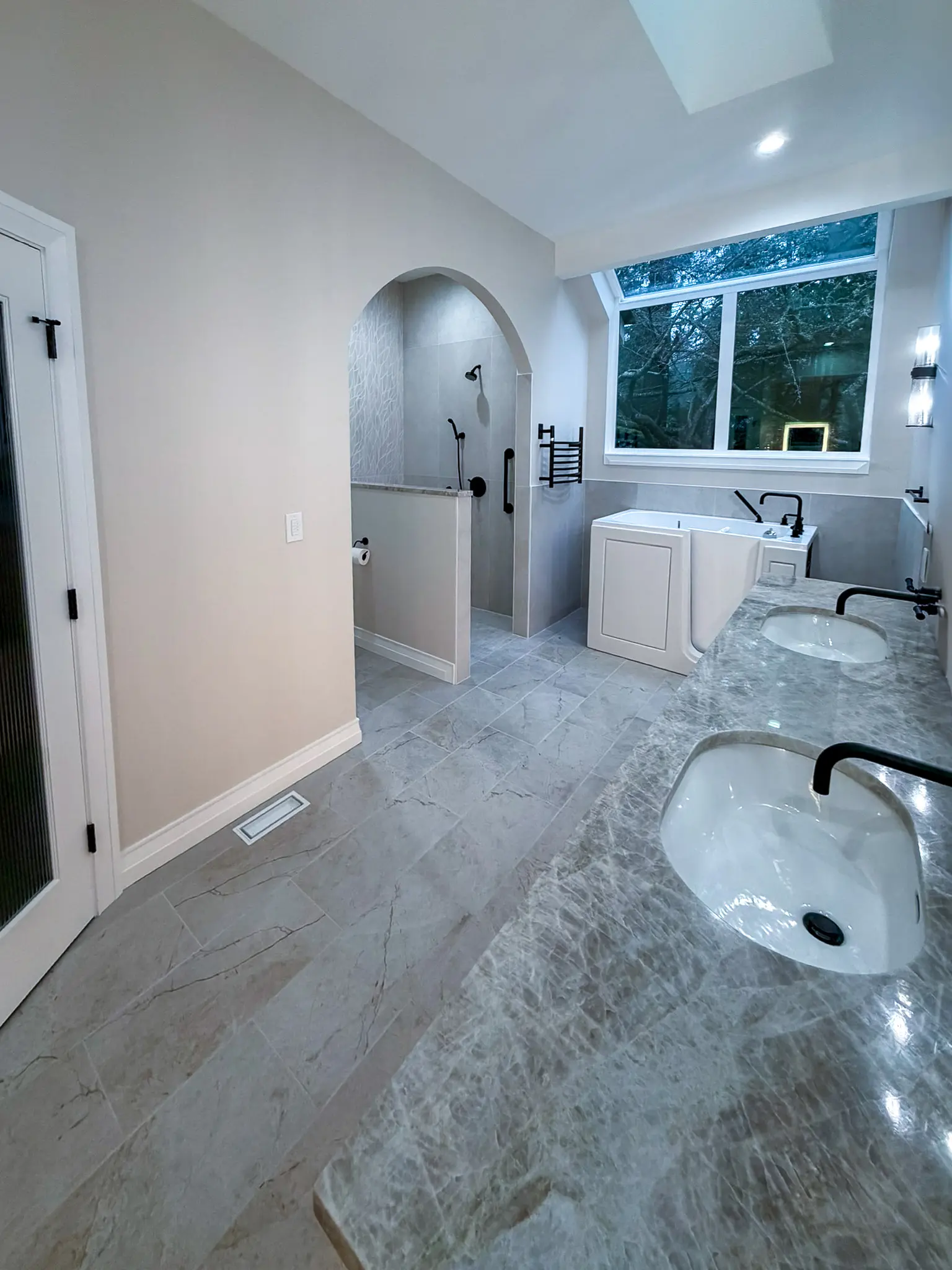 Primary bathroom with a curbless, open-entry shower and grab bar after an ADA-focused whole-home remodel in Sammamish, WA.