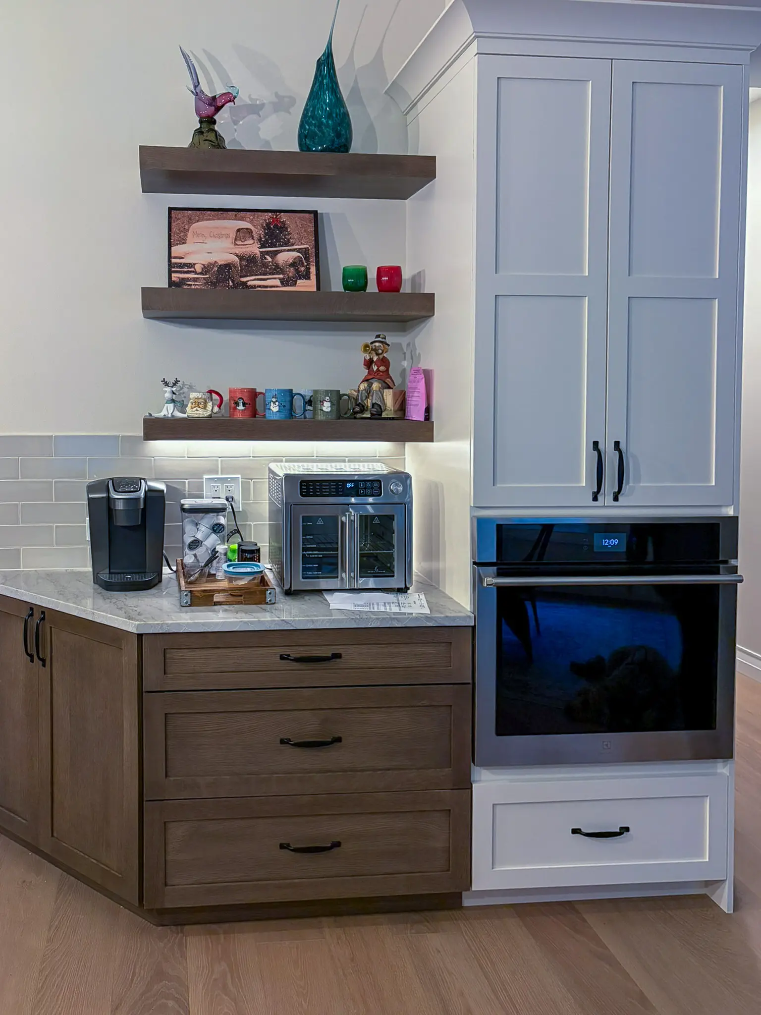 Kitchen cabinetry with open shelving and a built-in wall oven after a whole-home remodel in Sammamish, WA.