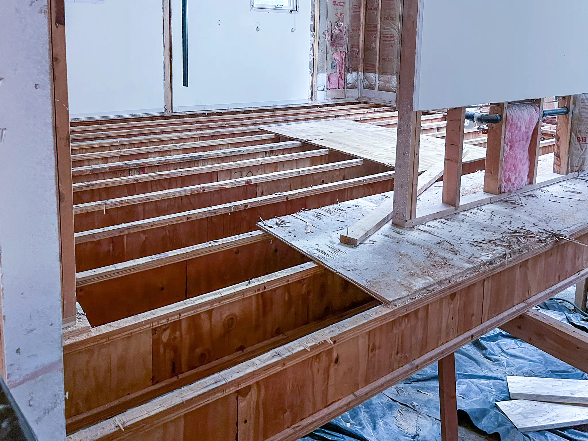 Exposed floor joists and wall framing being leveled during a whole-home remodel in Sammamish, WA.