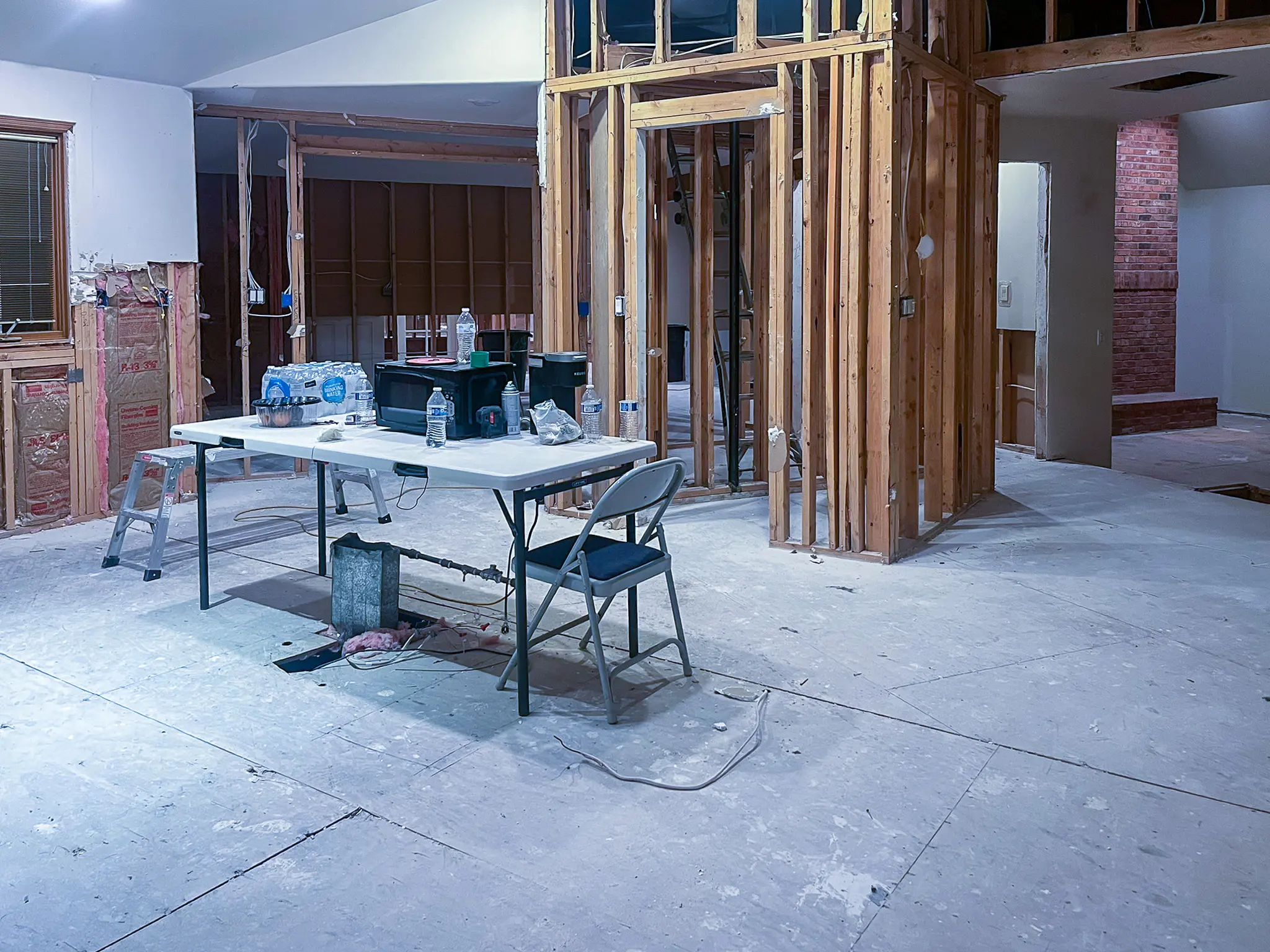 Interior gutted to the studs with exposed wall framing and subfloor before a whole-home remodel in Sammamish, WA.