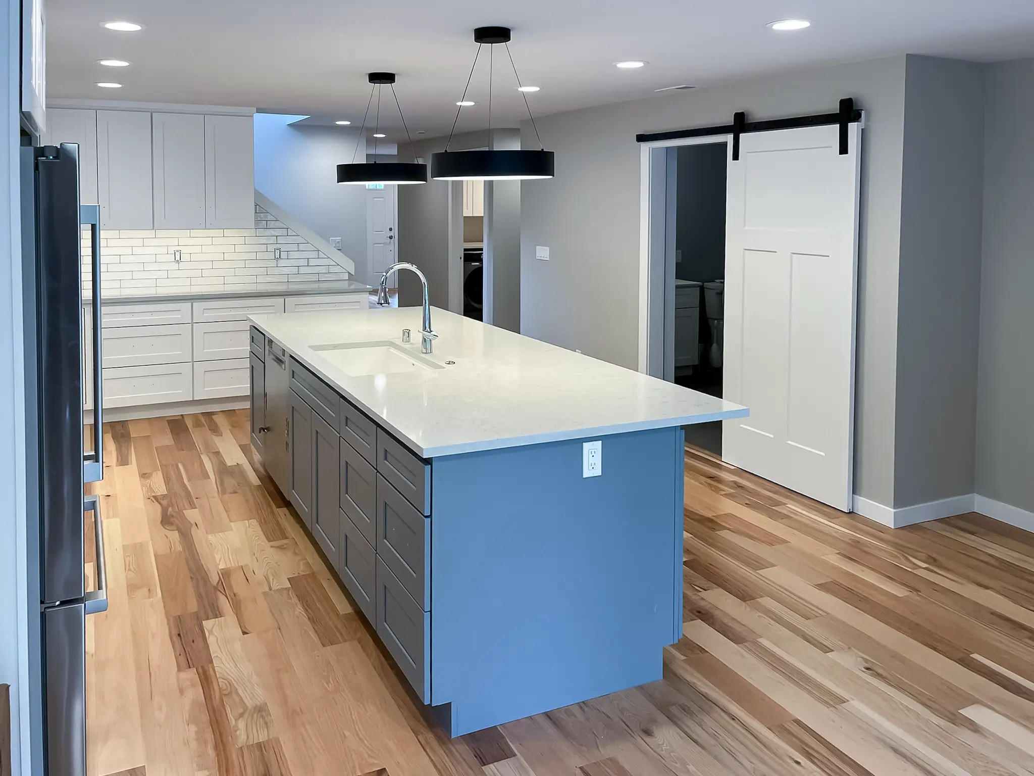 Angled view of the remodeled kitchen island and pendant lighting in a Kirkland, WA rambler.