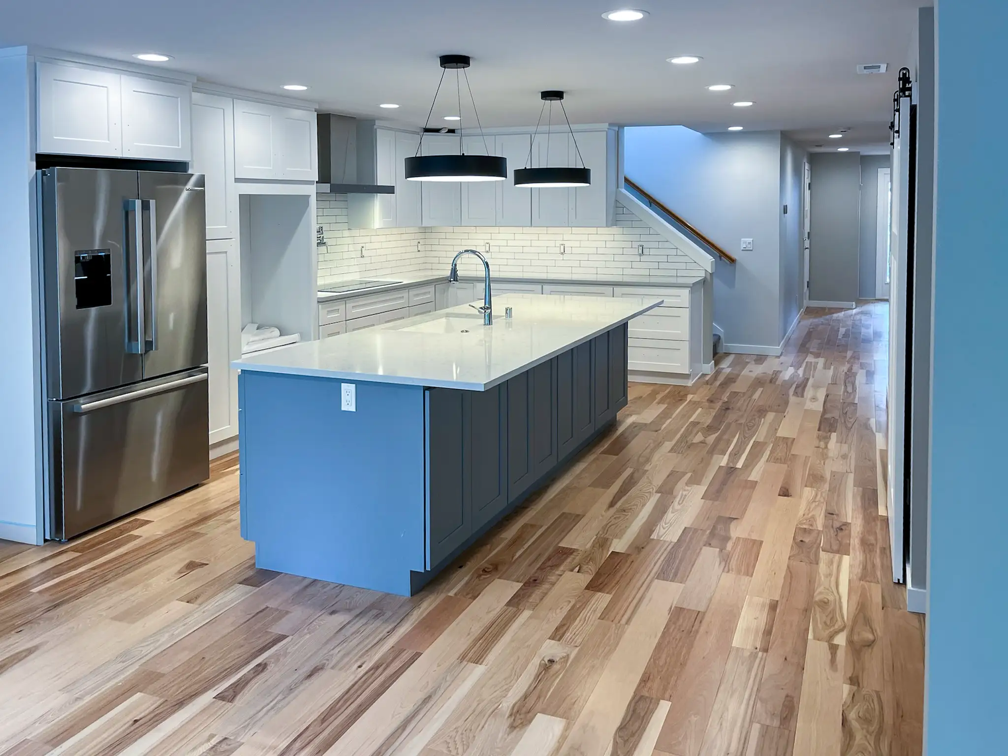 Remodeled kitchen in a Kirkland, WA rambler with white shaker cabinets, a subway tile backsplash, and a quartz-look island.