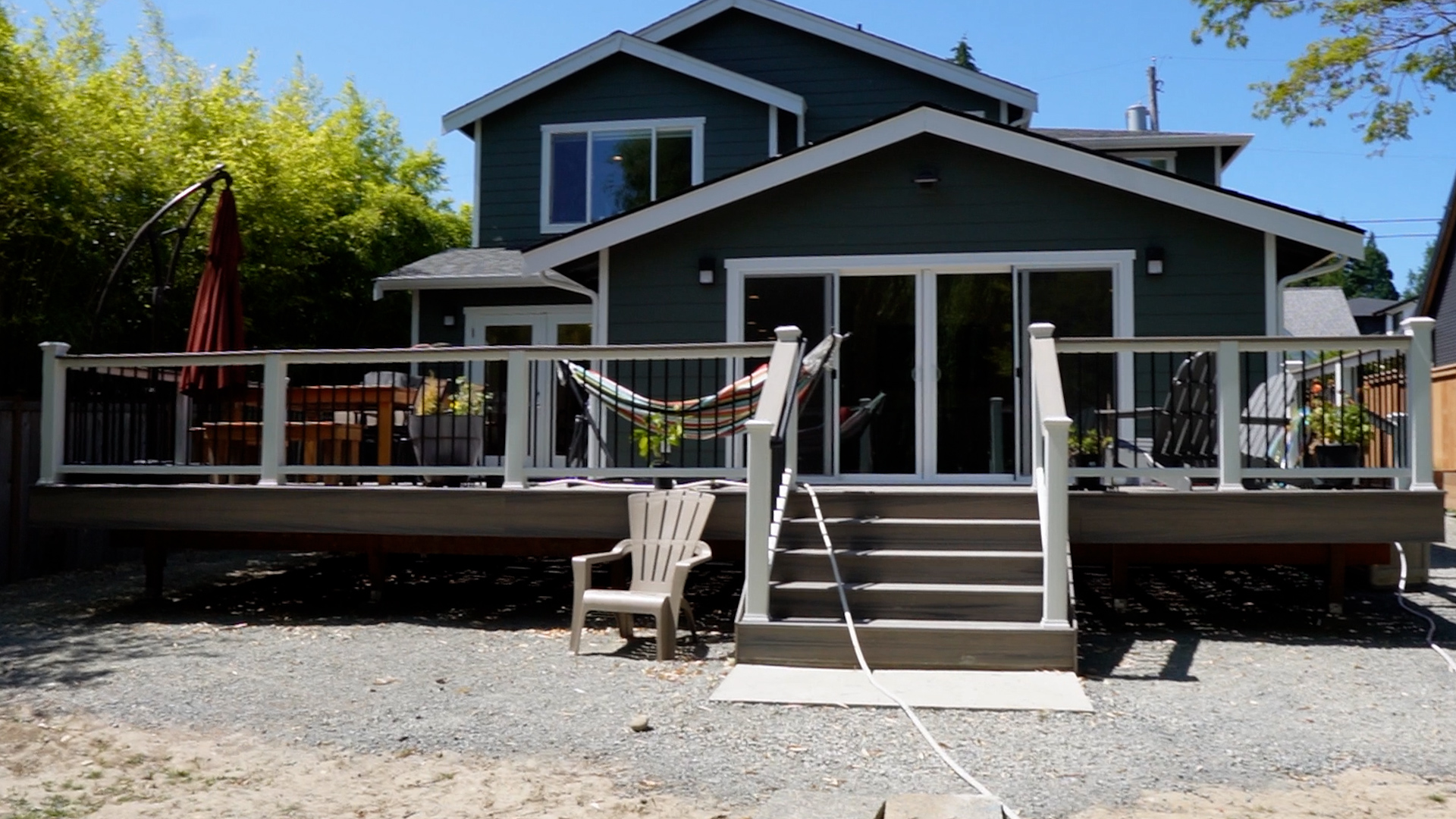 Wide view of the rebuilt composite backyard deck with white railings at a Kirkland, WA rambler.