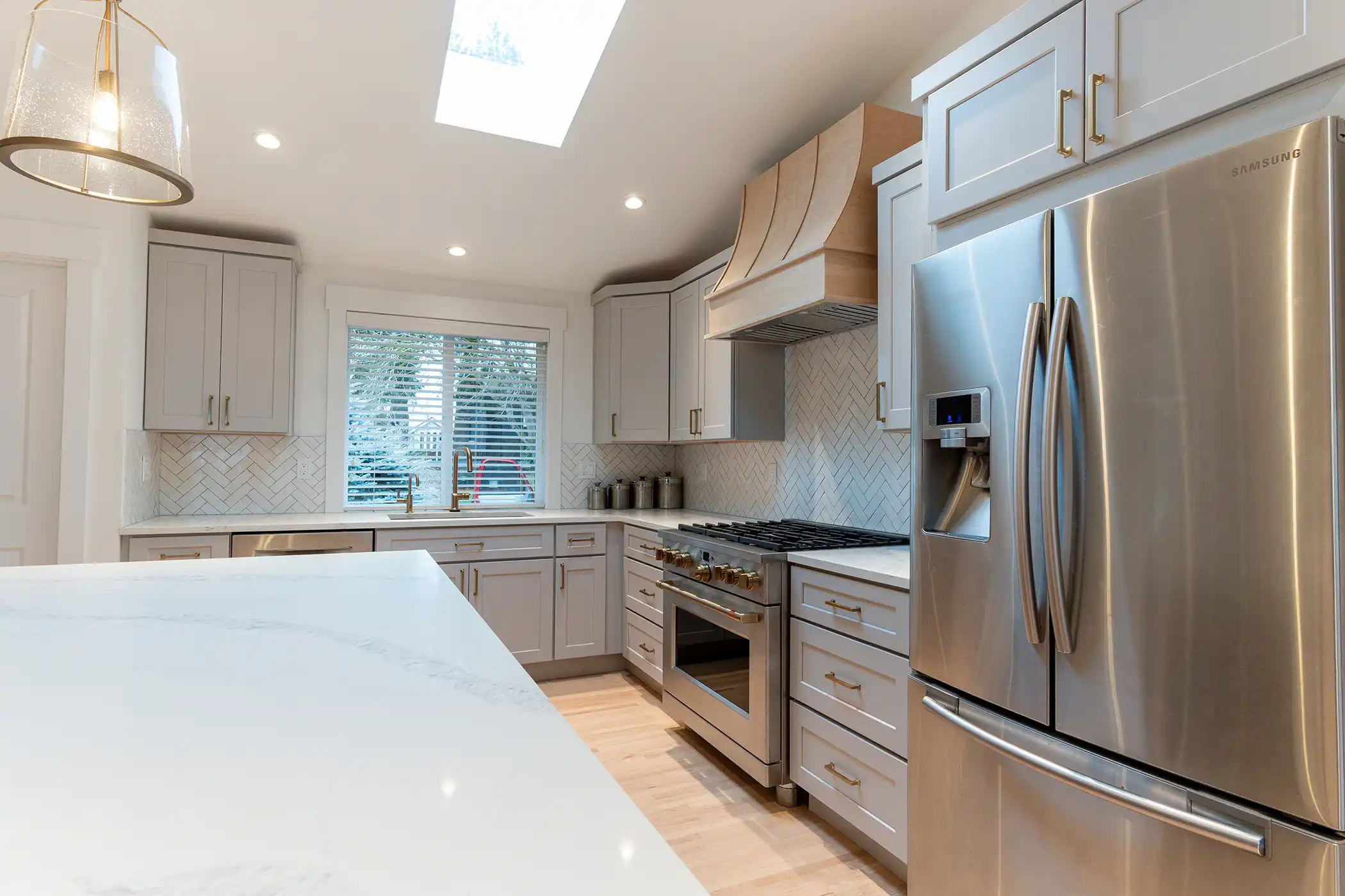 Kitchen with a paneled built-in refrigerator and quartz-look countertops after a Kirkland, WA kitchen and bathroom remodel.