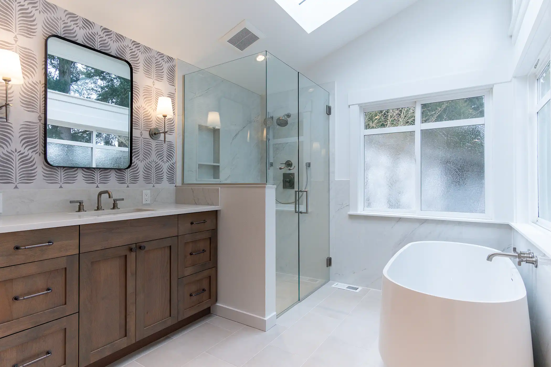 Angled view of the soaking tub and glass shower in the remodeled bathroom of a Kirkland, WA home.