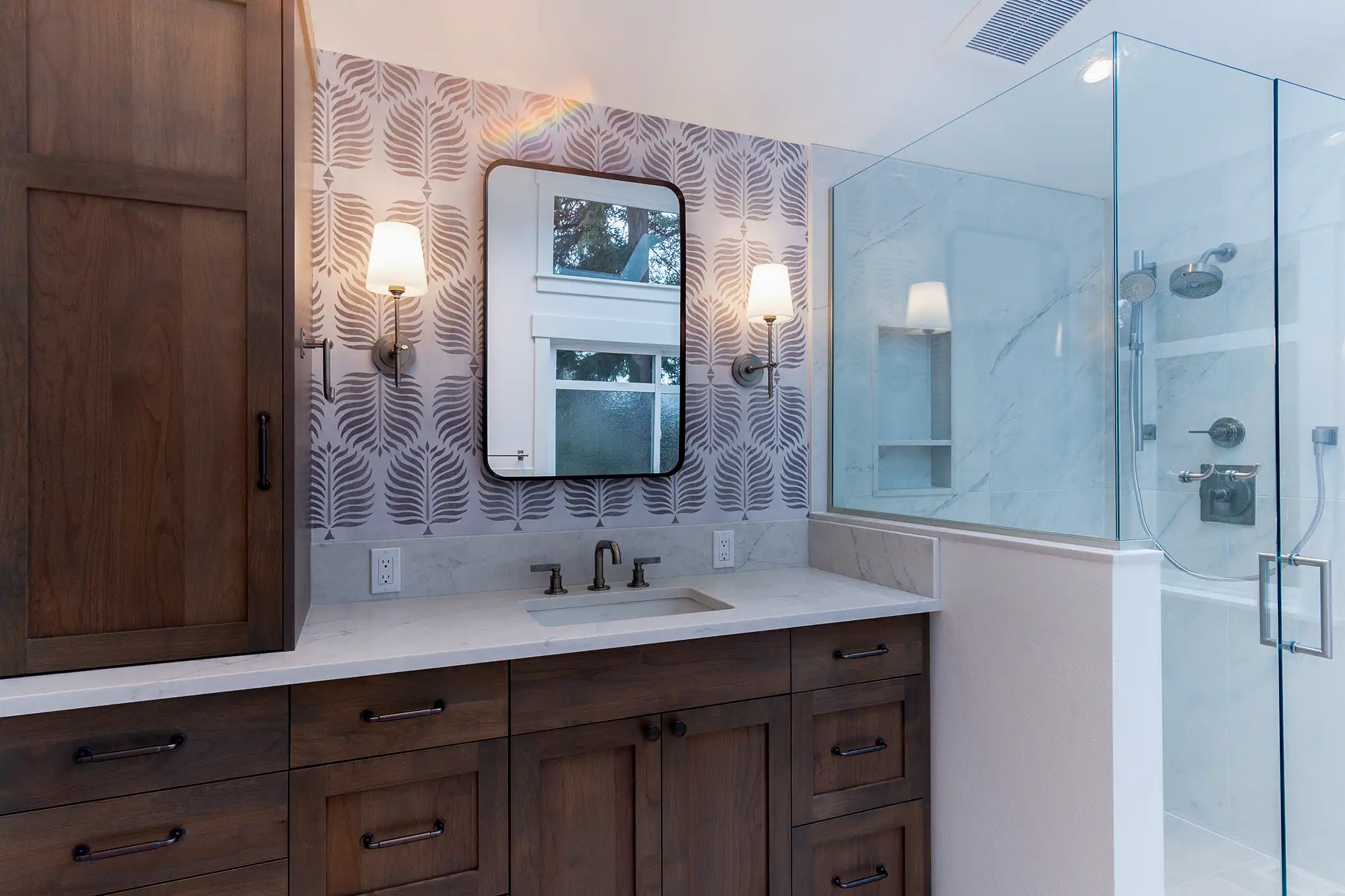 Wood vanity with quartz countertop and black hardware in the remodeled bathroom of a Kirkland, WA home.