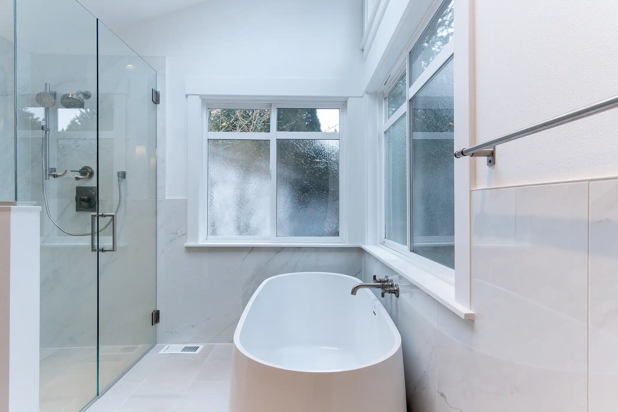 Overhead view of the freestanding soaking tub near a frosted window in the remodeled bathroom.