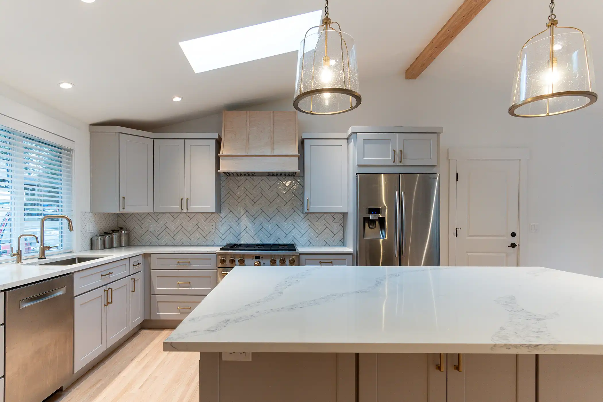 Front view of the remodeled kitchen with shaker cabinets and a waterfall island in a Kirkland, WA home.