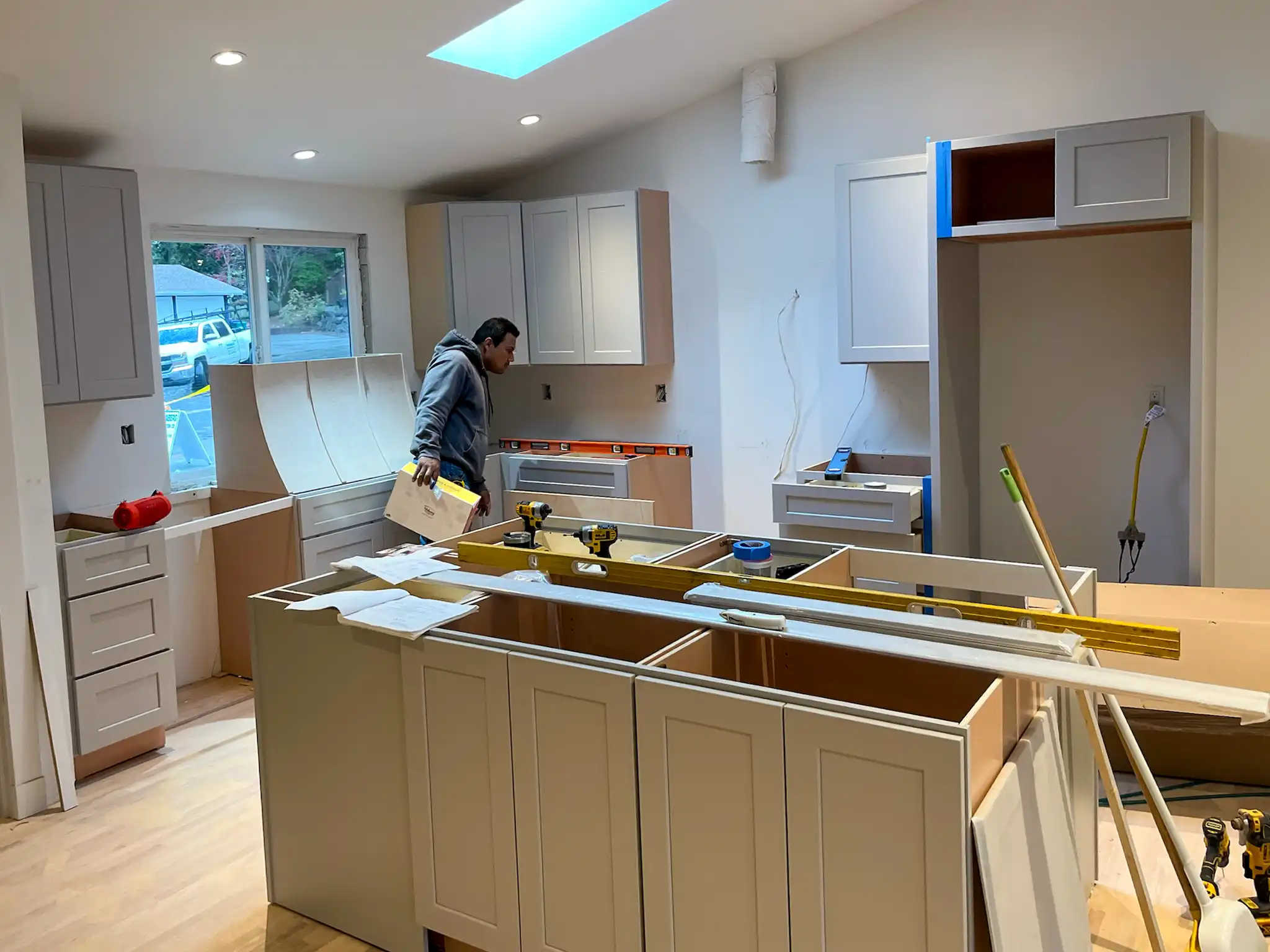Wide view of the kitchen midway through cabinet installation during the remodel.