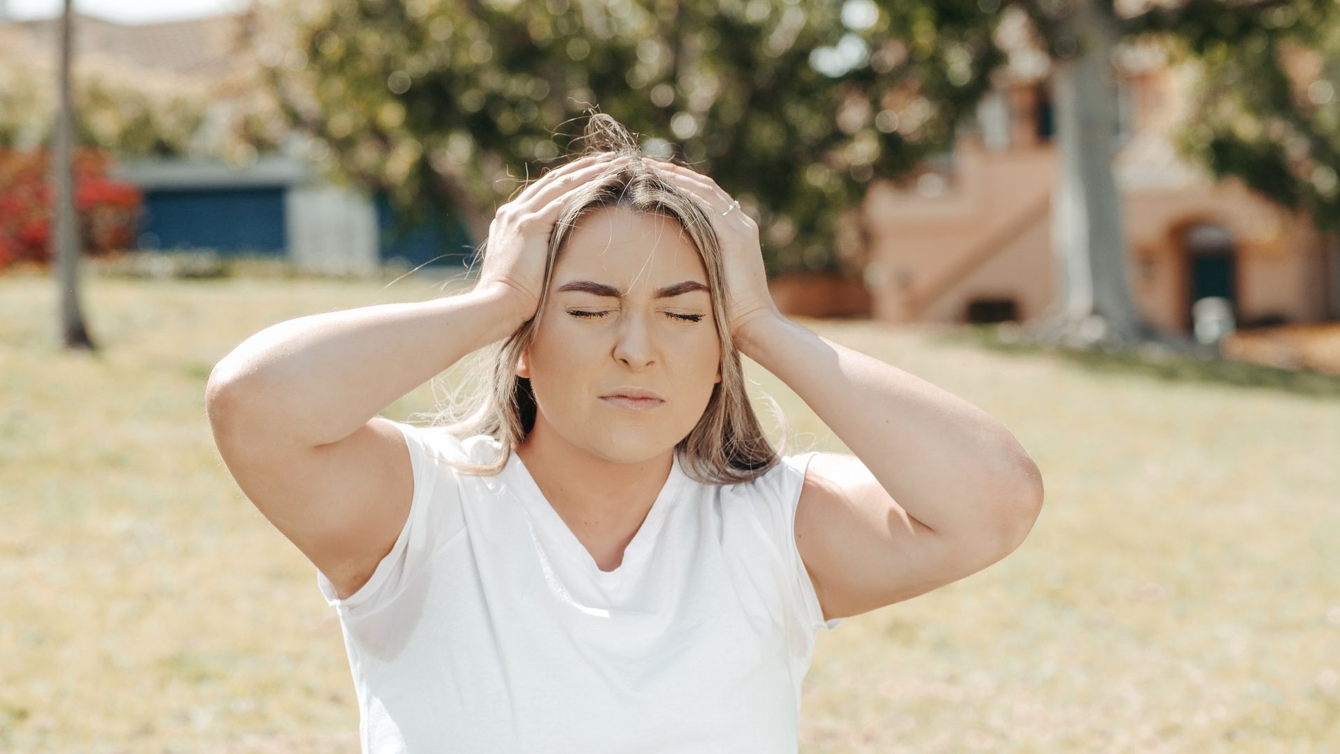 Woman with eyes closed experiencing migraine pain