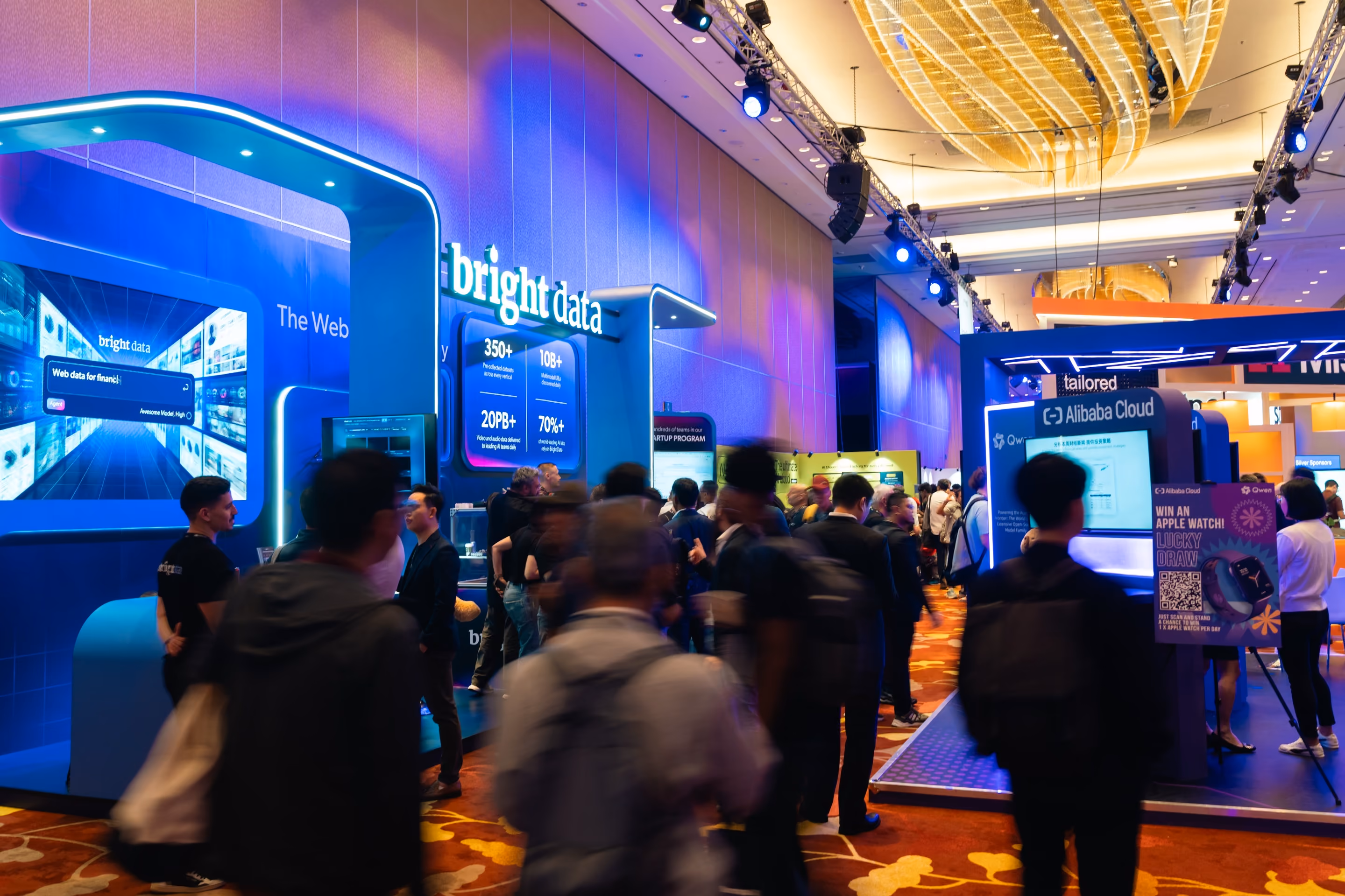 Crowd gathered at the Bright Data booth, with data statistics displayed on a large screen.