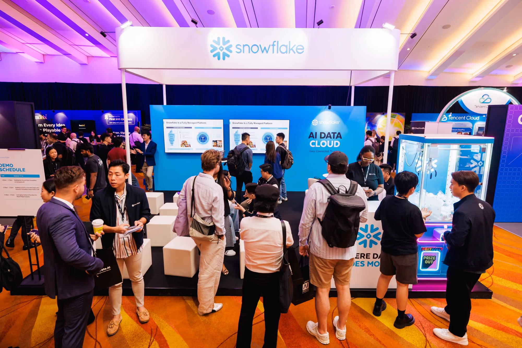 Crowd gathered at the Snowflake "AI Data Cloud" booth viewing demo screens at SuperAI 2026.