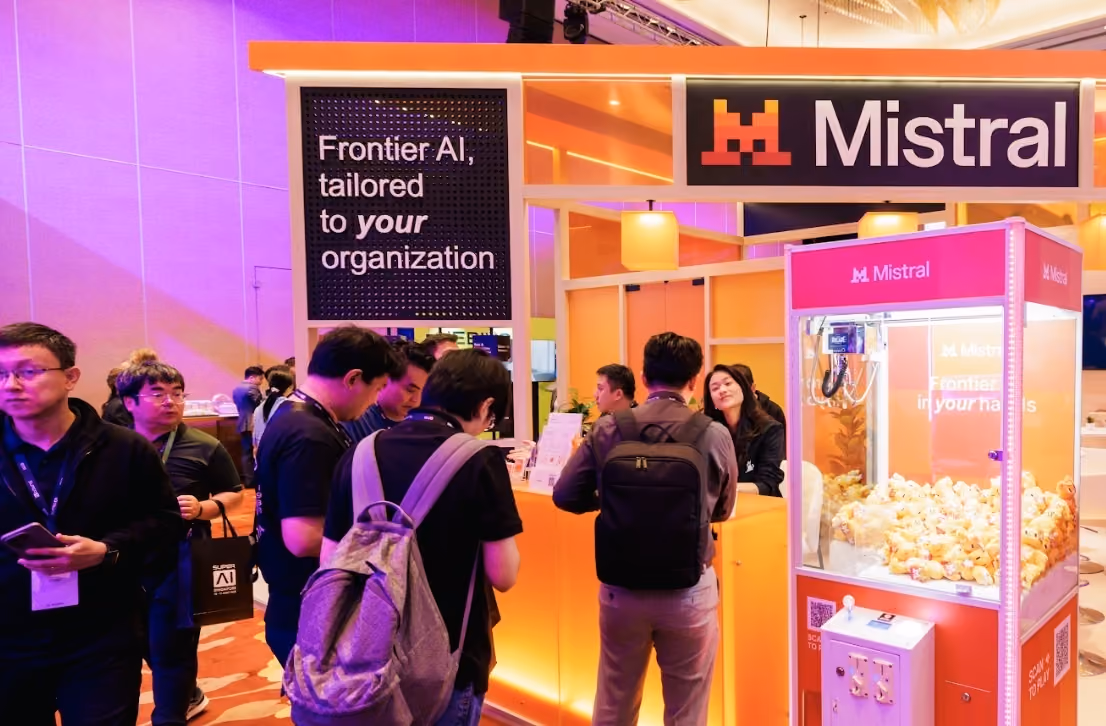 Attendees at the Mistral booth beneath a "Frontier AI, tailored to your organization" sign at SuperAI 2026.