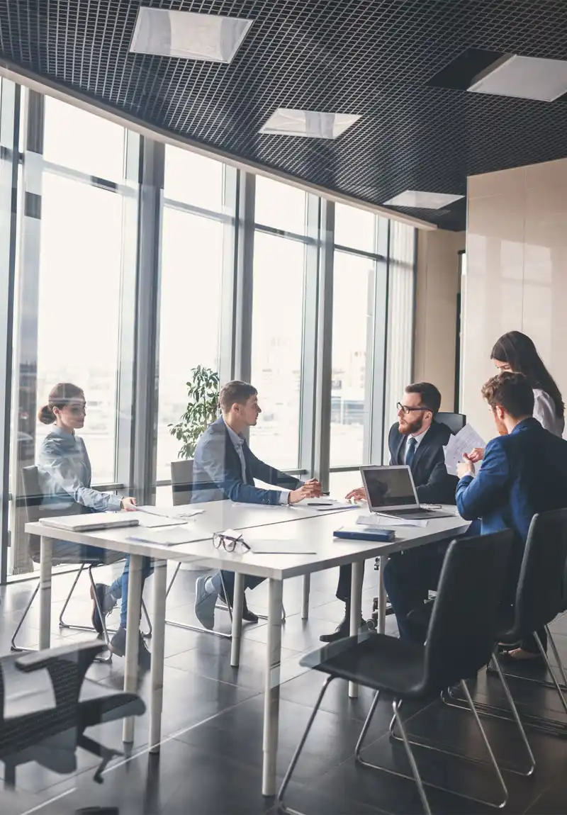 People having a business meeting in conference room surrounded by glass