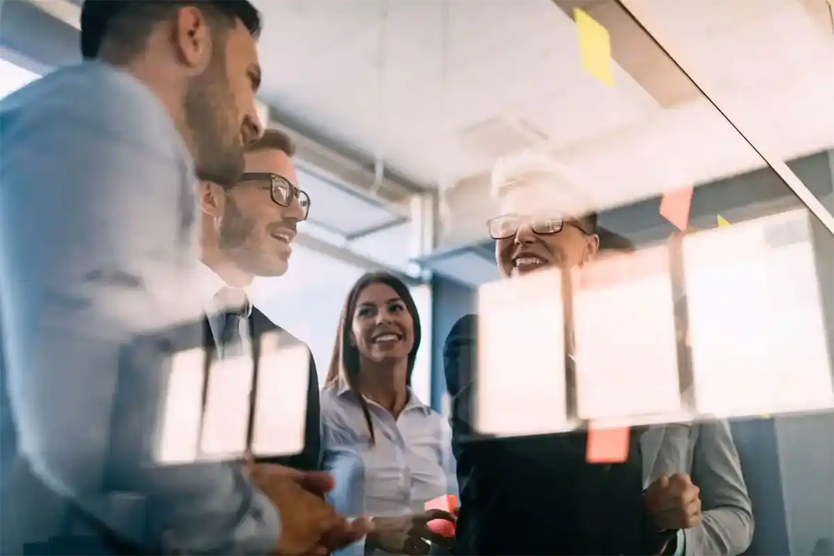People talking in conference room surrounded by glass
