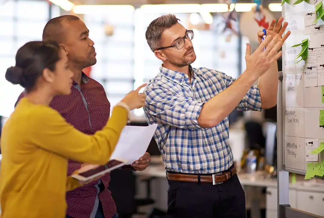Guy with glasses showing couple post-it board