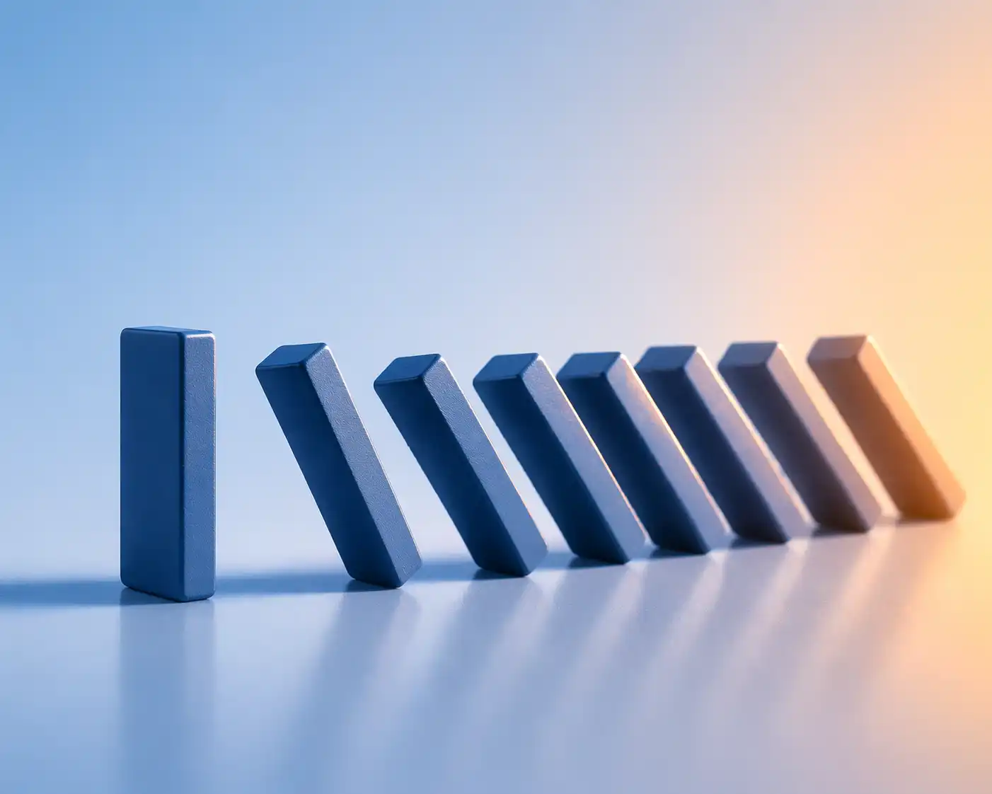 Dark blue dominos on light blue background in a line falling and collapsing