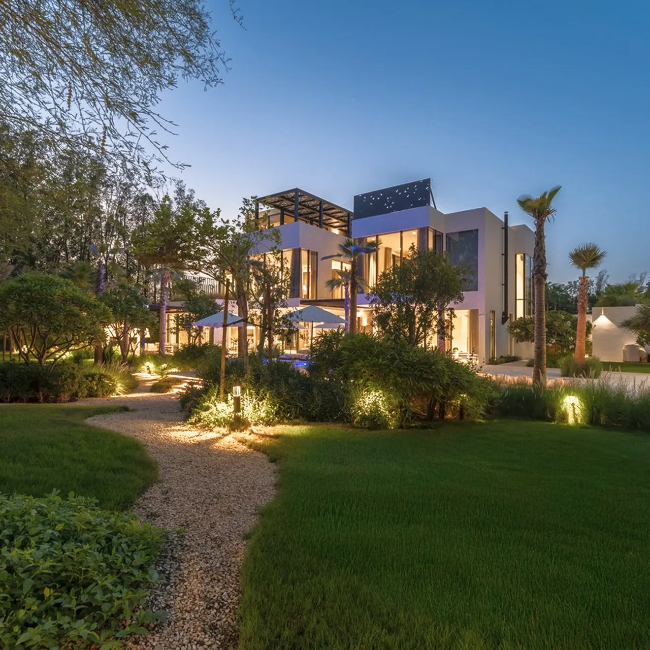 Custom designed landscaping with a gravel path in a luxury villa