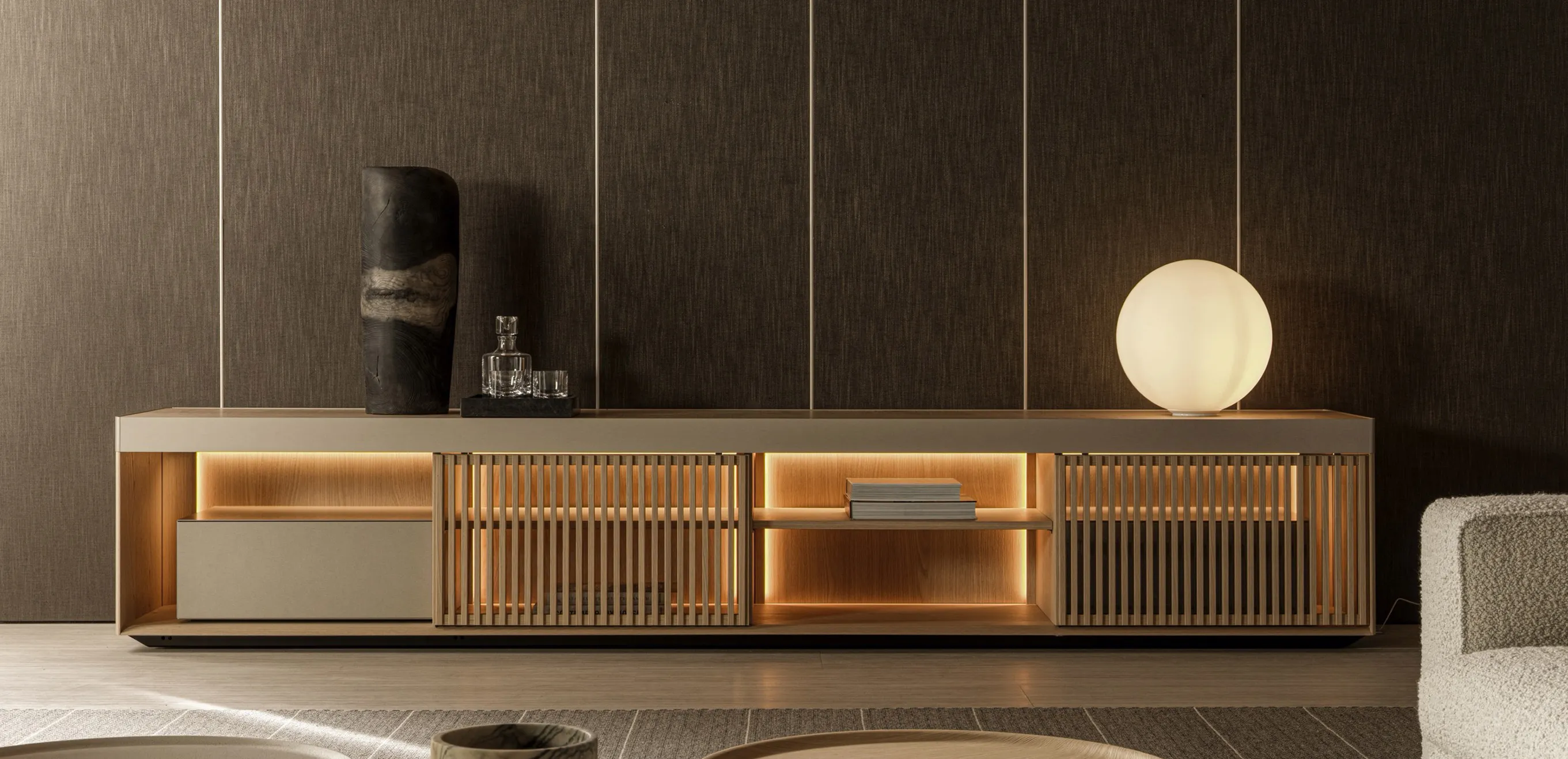 Contemporary low console unit with warm backlighting, slatted sliding doors, and matte lacquer finish.