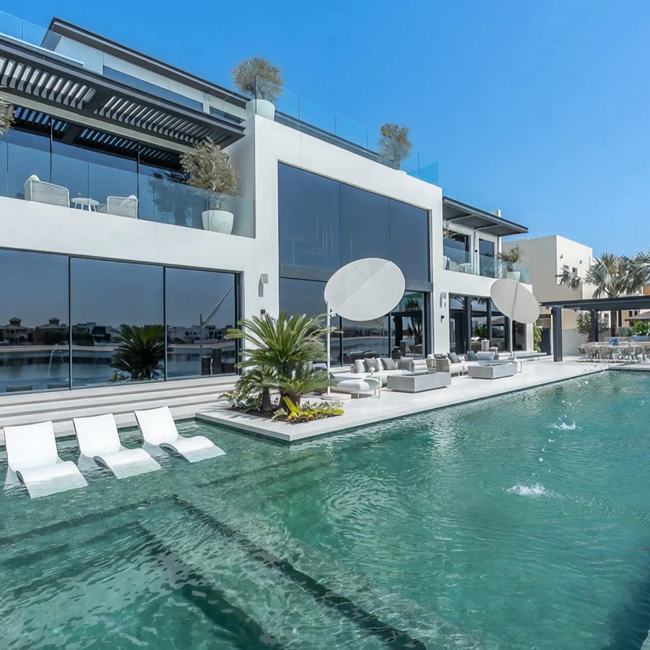 Contemporary villa architecture design in Palm Jumeirah with integrated pool, and water feature.