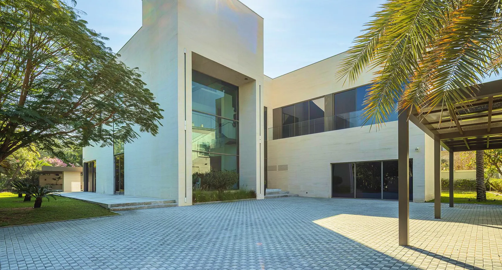 Luxury villa featuring expansive glass and lush greenery in Emirates Hills