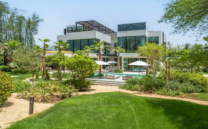 Luxury villa with a built-in pool and lush green landscaping in AL Barari