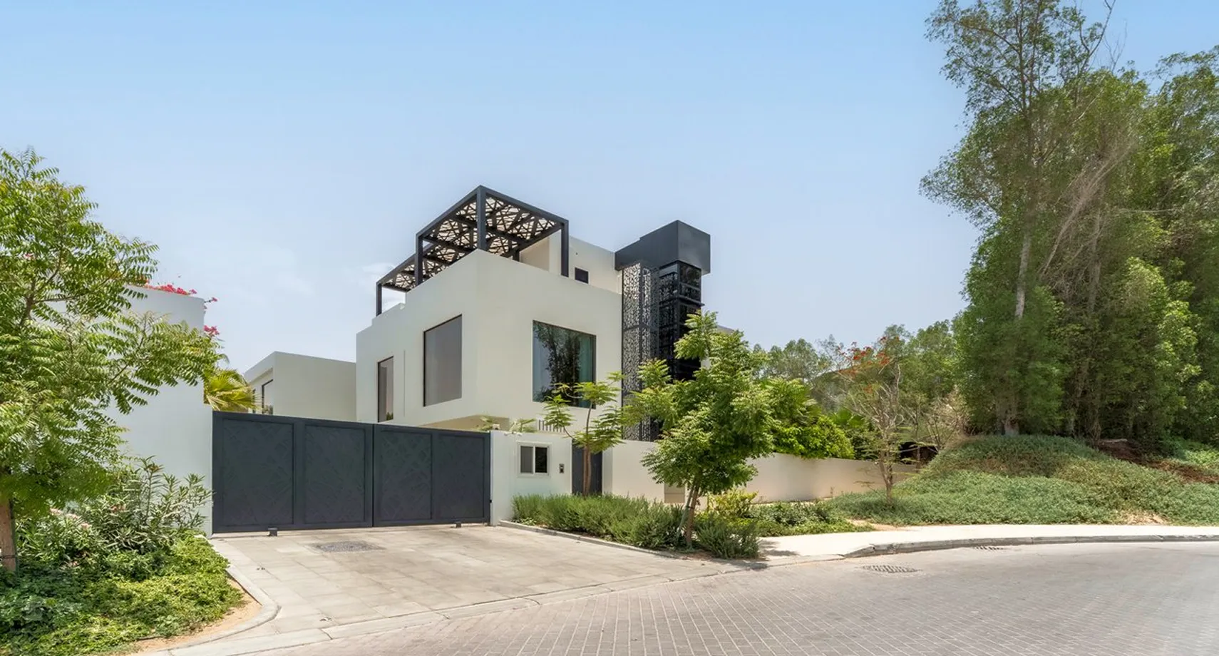 A modern white villa surrounded by green landscaping