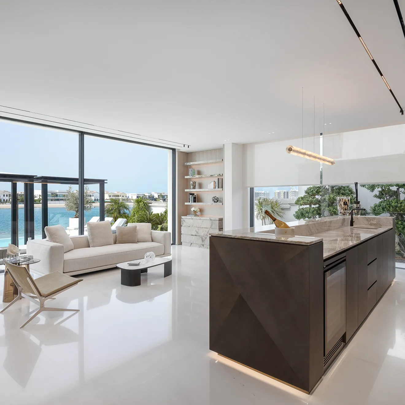 Living area in a palm villa with custom-designed modular sofas and floor-to-ceiling glass windows