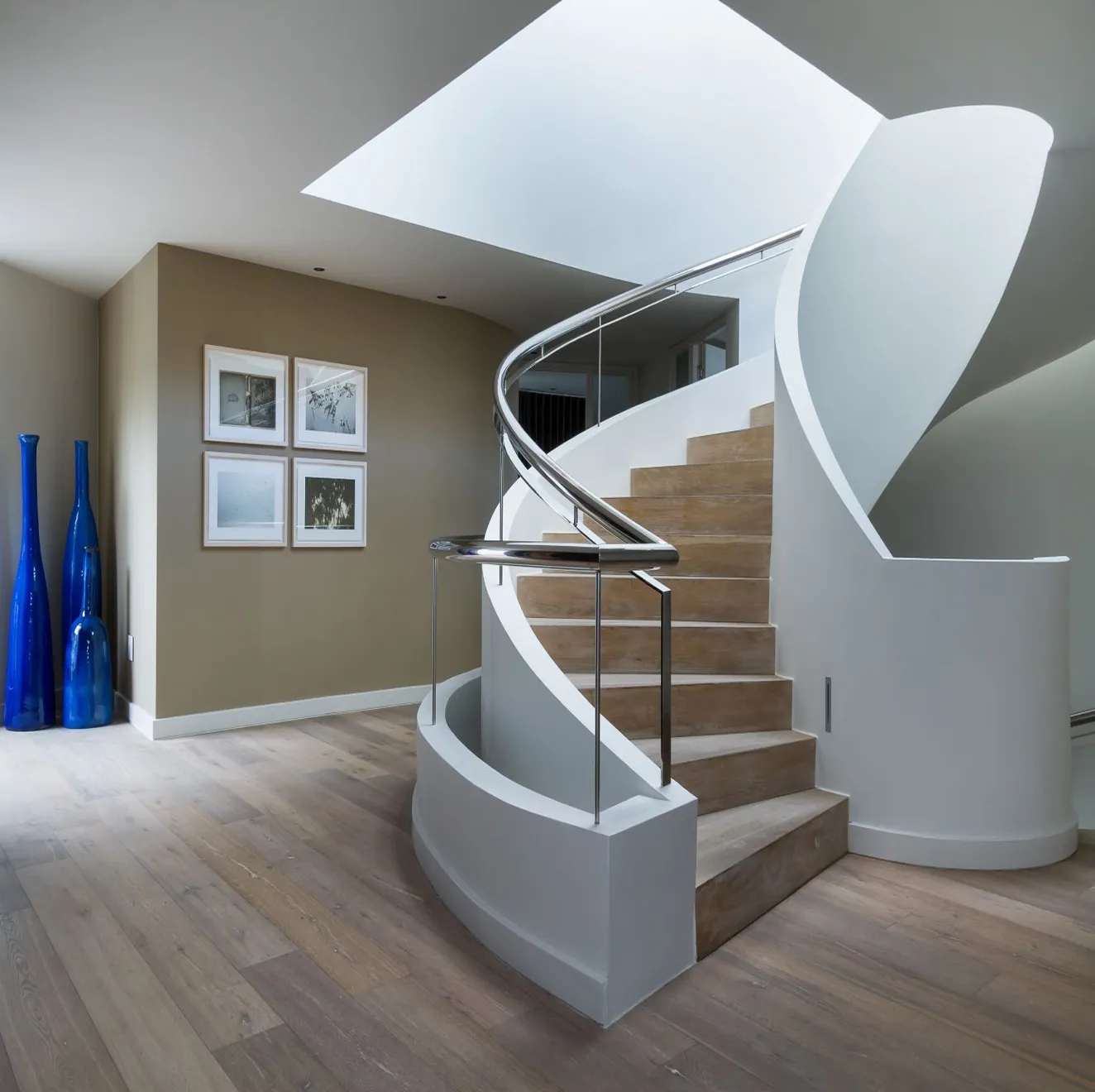 Luxury interior design featuring a curved light‑wood staircase