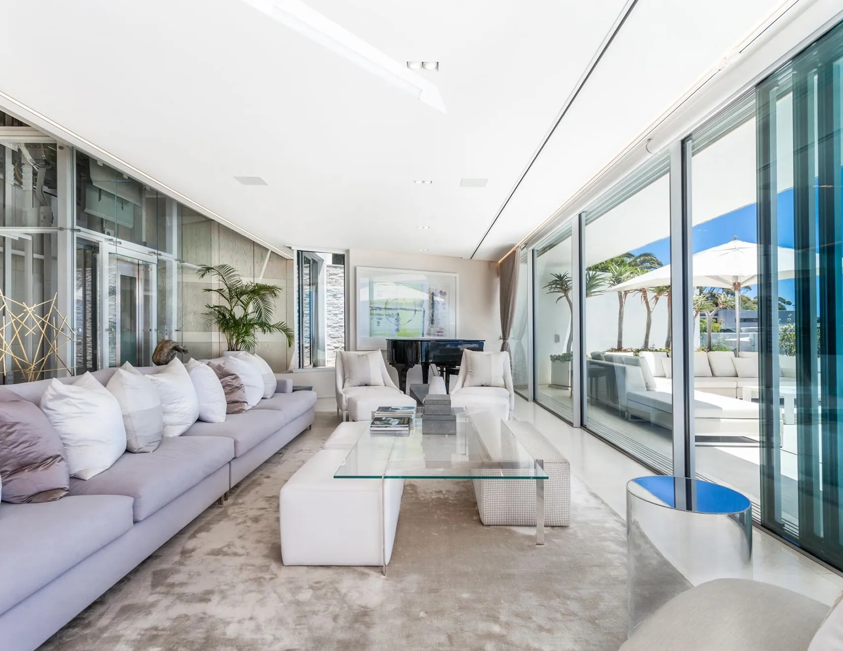 Luxurious modern living room interior design featuring modular sofas, a grand piano, and floor-to-ceiling glass